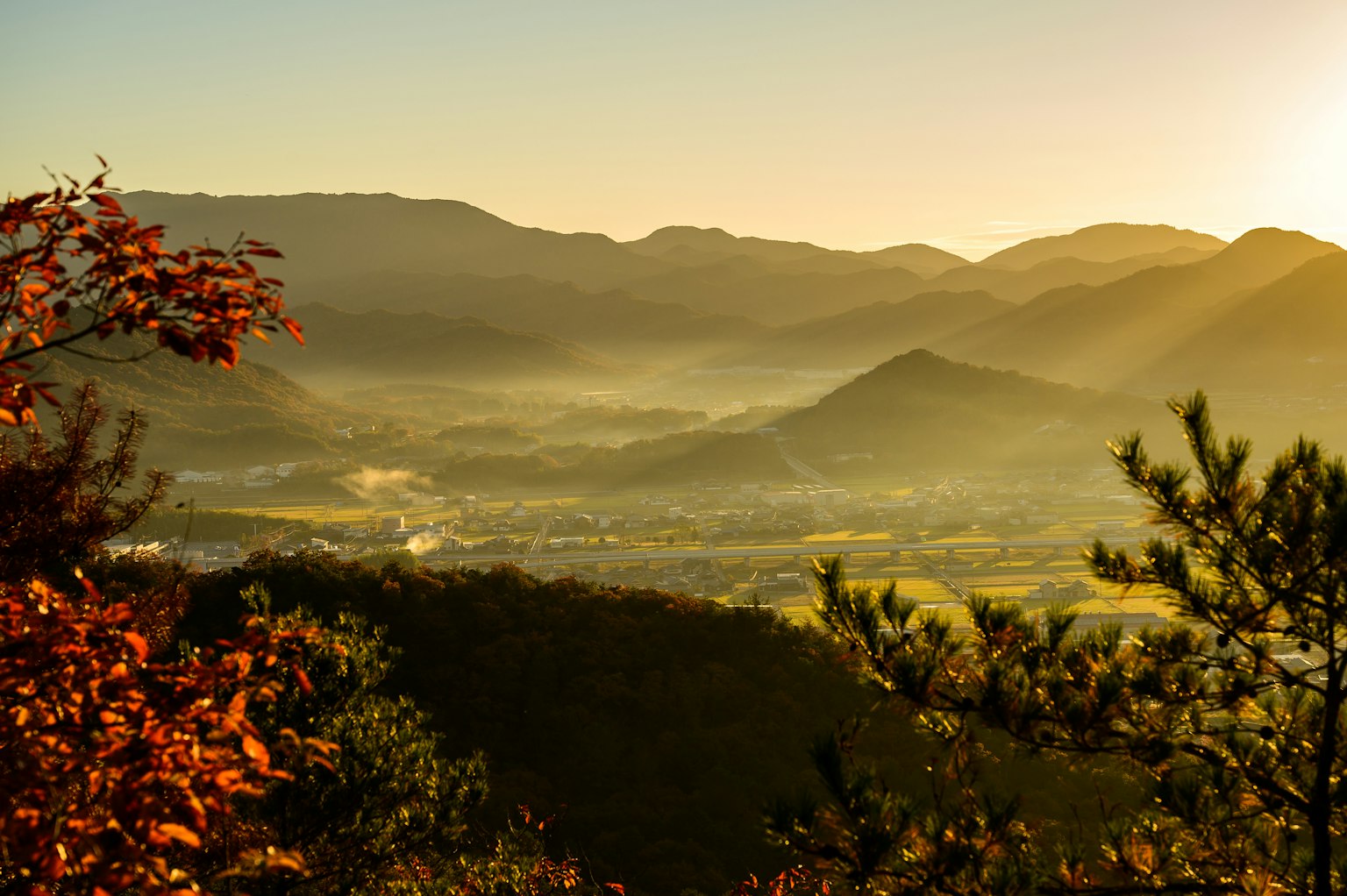 Malersicher Blick auf Berge und ein nebliges Tal bei Sonnenaufgang