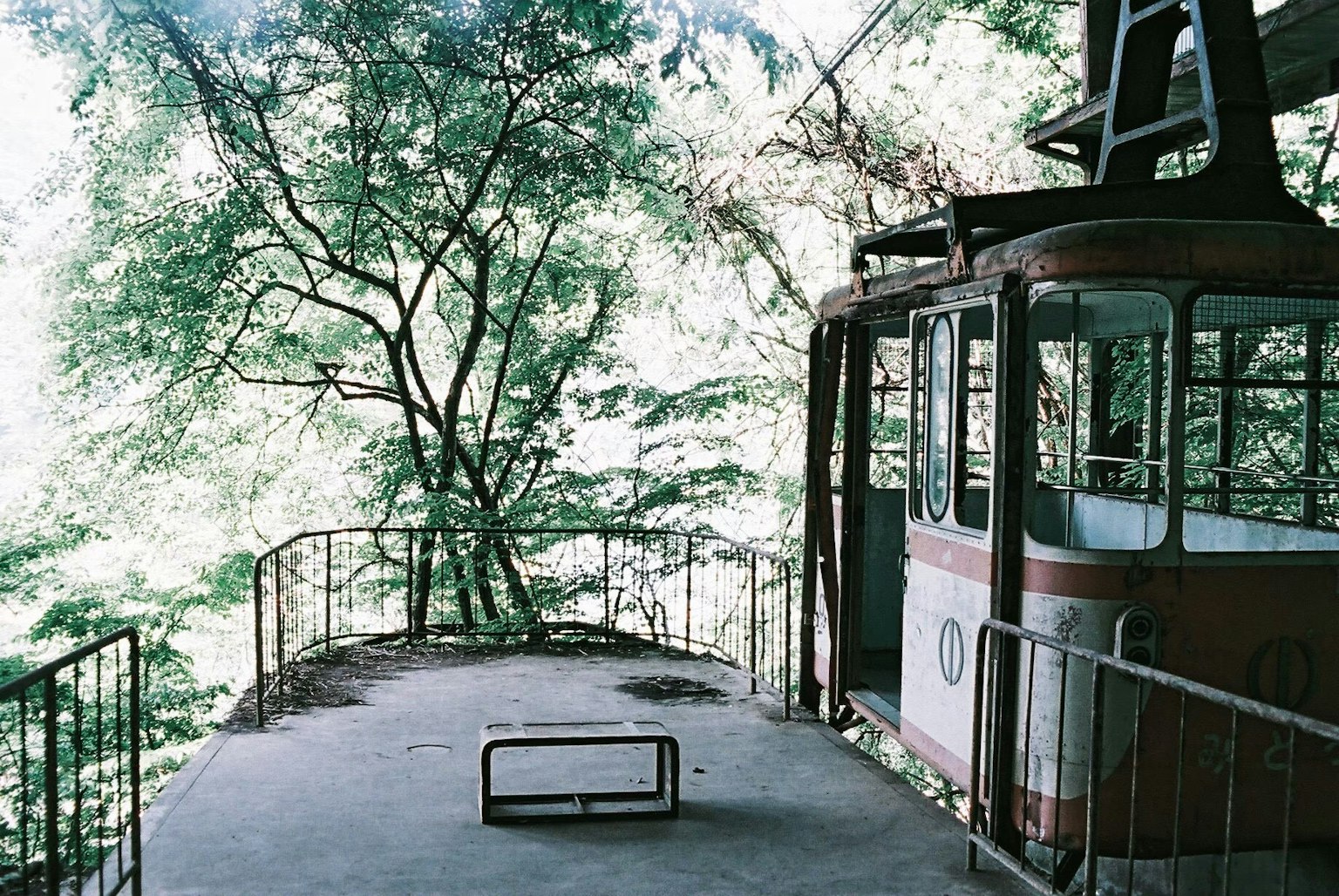 Stazione di funivia abbandonata circondata da alberi verdi lussureggianti