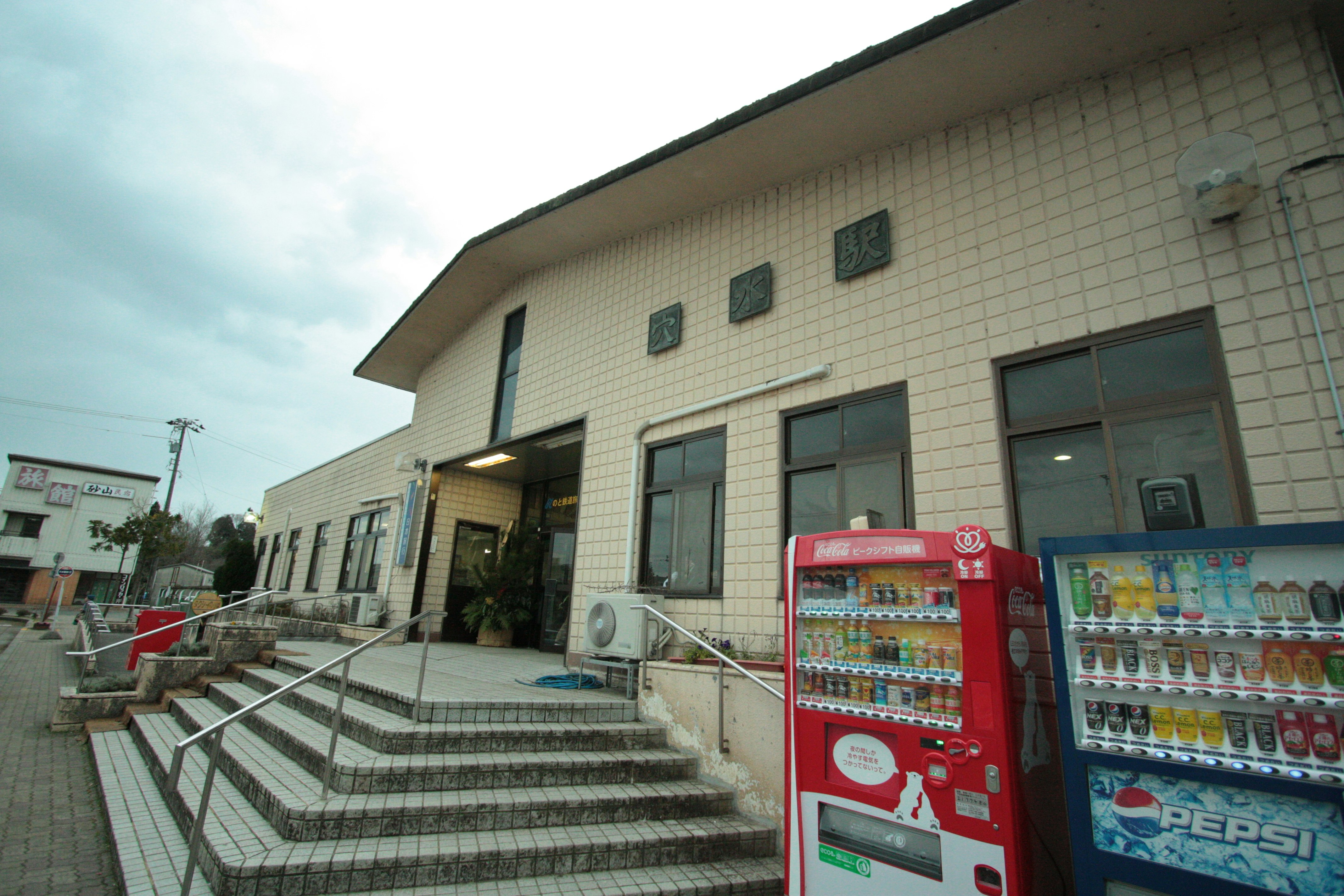 階段のある建物入口と飲料の自販機