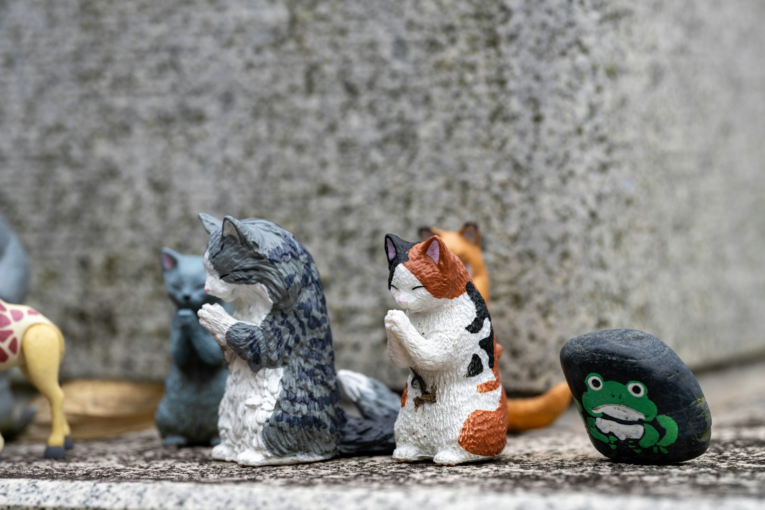 Bild von kleinen Katzenfiguren, die in verschiedenen Farben und Mustern angeordnet sind