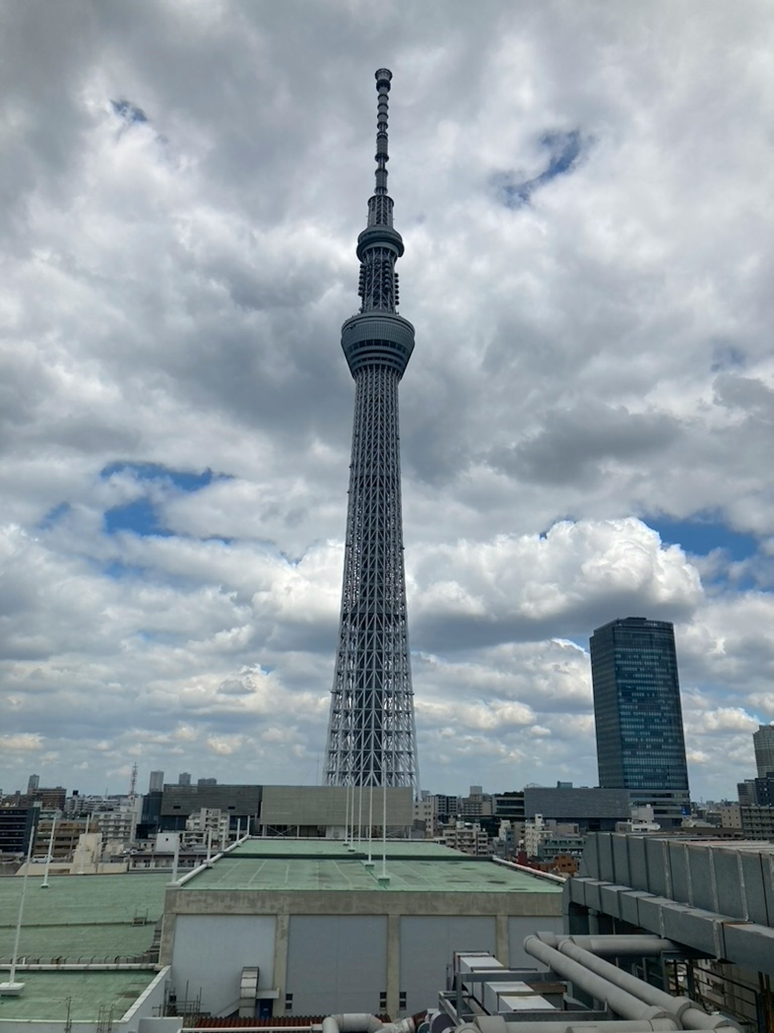 Tokyo Skytree se dressant contre un ciel bleu et des nuages blancs