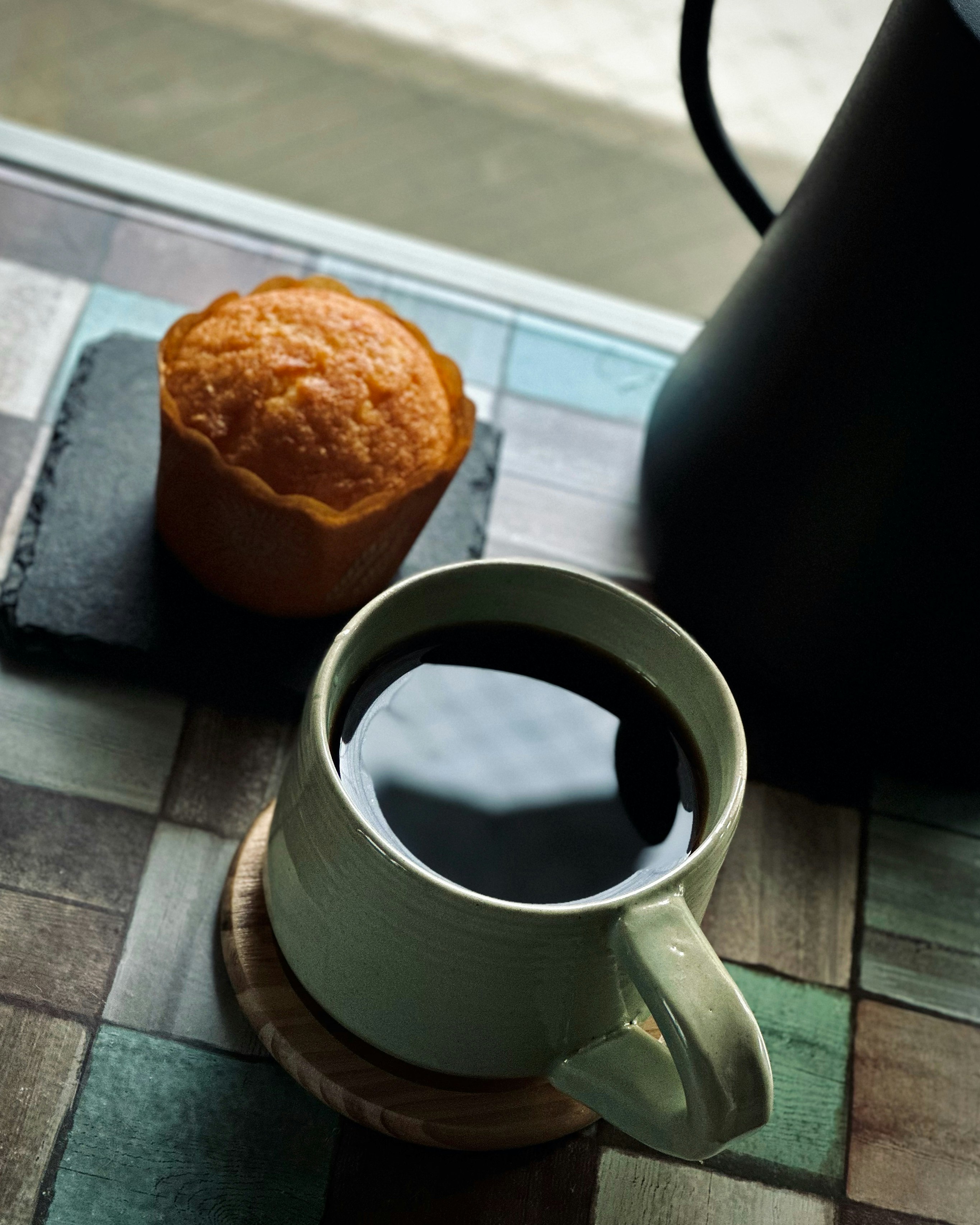 Coffee mug by the window with a muffin