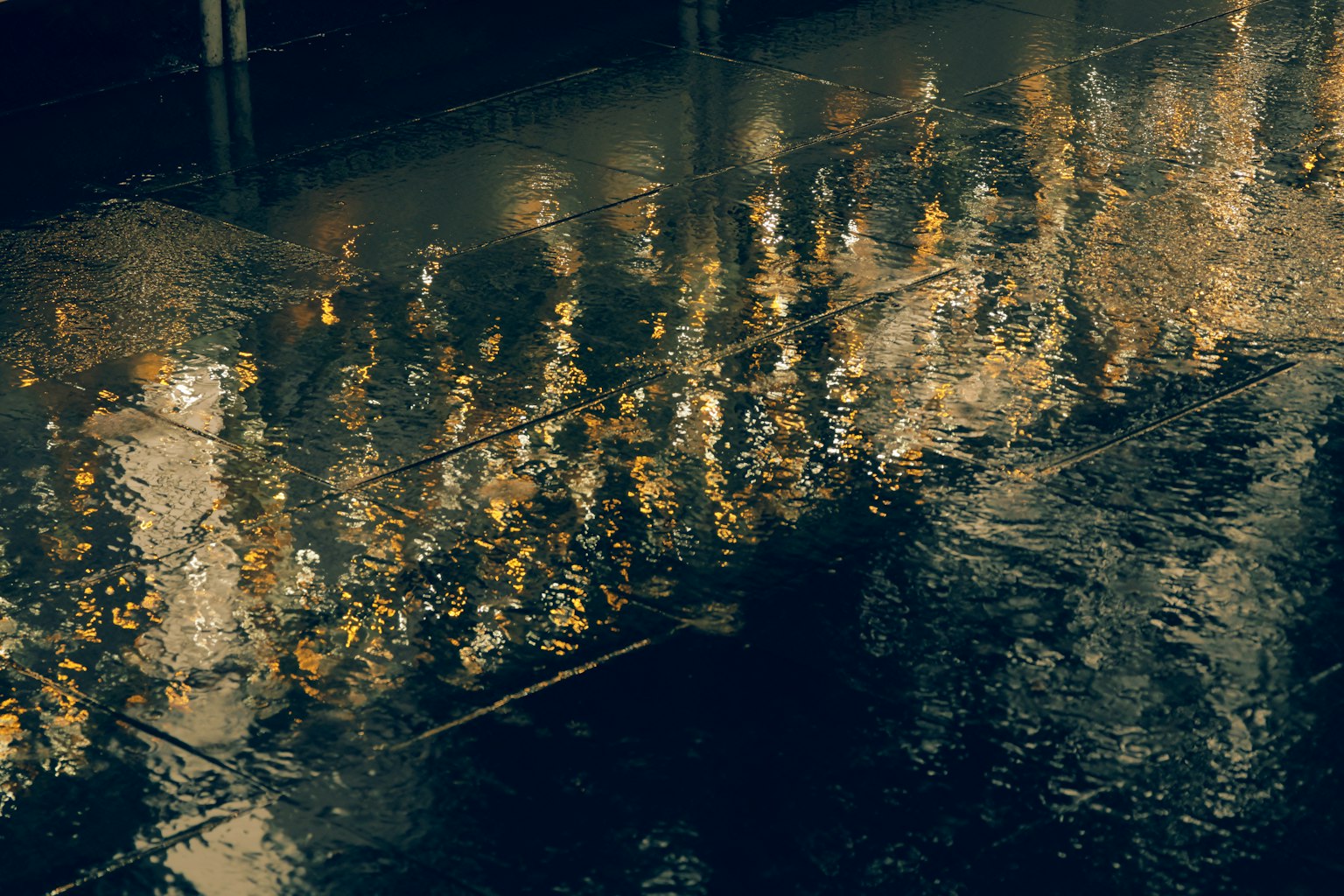 Reflection of city lights in a rain puddle