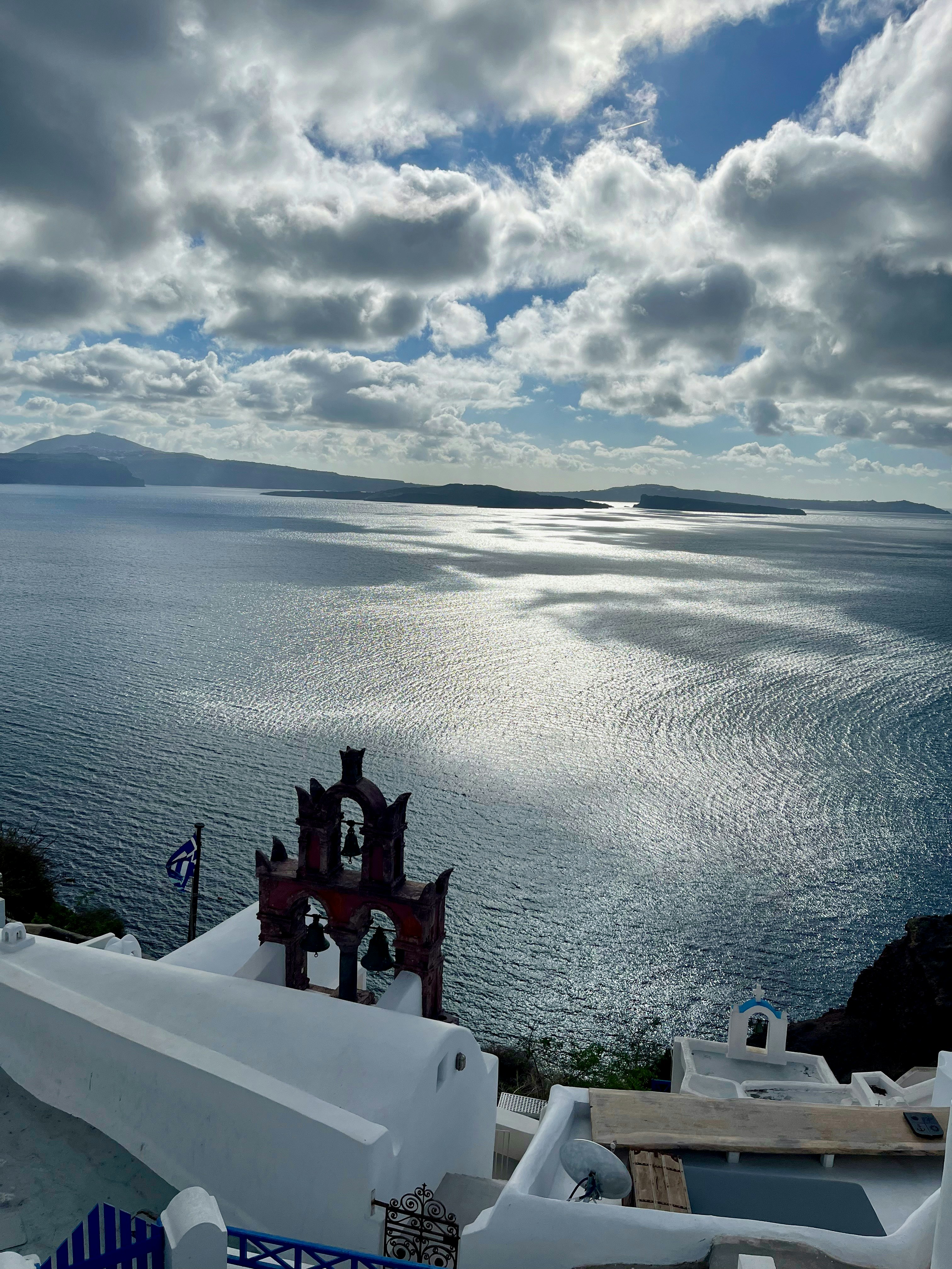 white terrace with blue roof ornament overlooking the sea