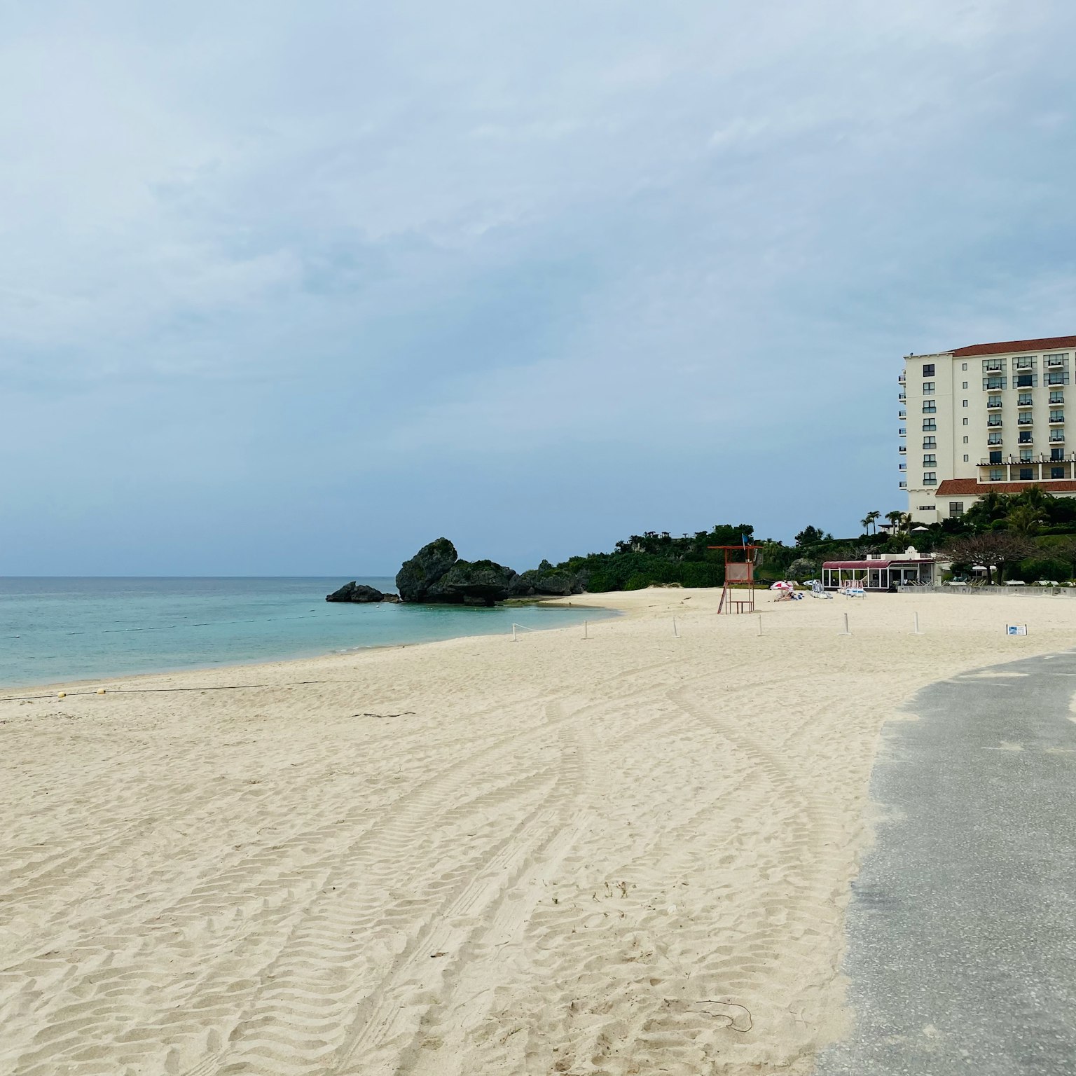 Vista panoramica della spiaggia con sabbia bianca e oceano blu Hotel alto sullo sfondo
