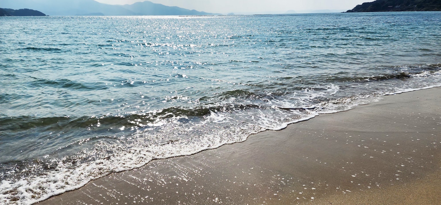 Vue panoramique d'un océan bleu avec des vagues douces sur une plage de sable