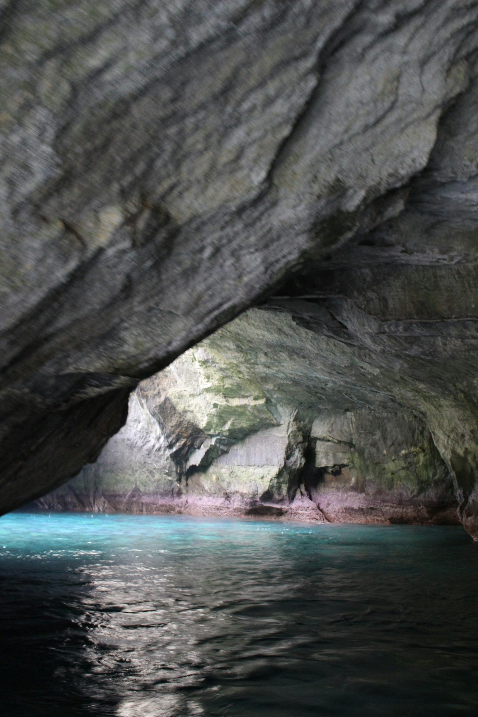 Interior de cueva con agua turquesa y paredes rocosas