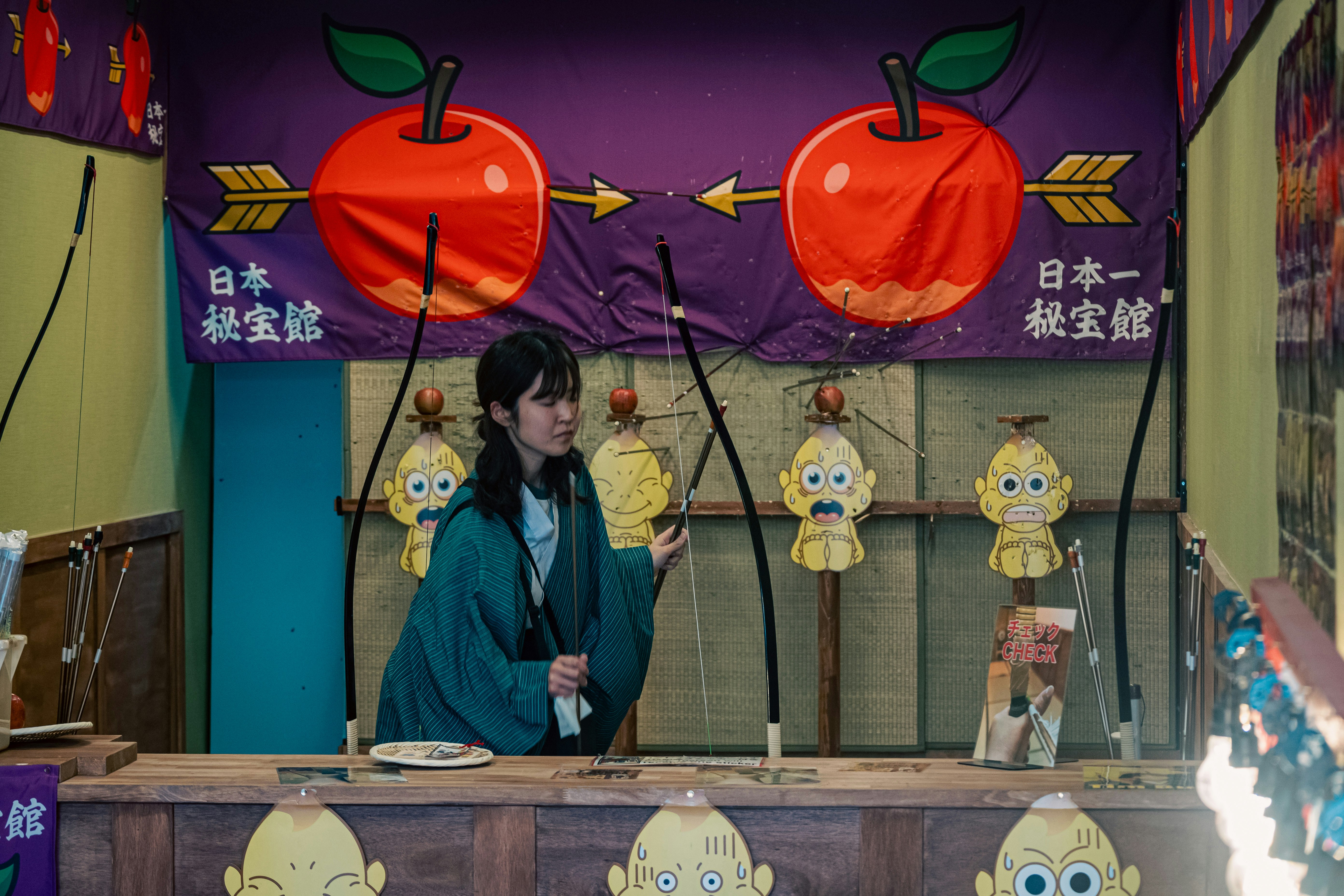 person standing behind a stall-style counter with Japanese signage