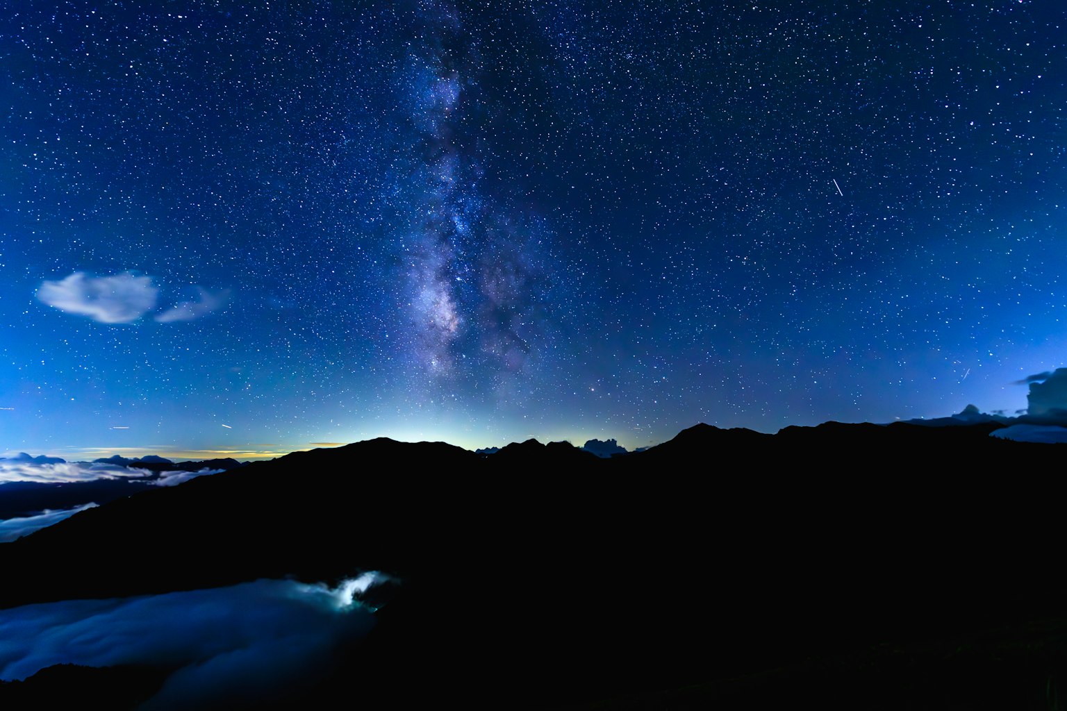 Atemberaubende Landschaft von Bergen unter einem sternenklaren Himmel mit der Milchstraße