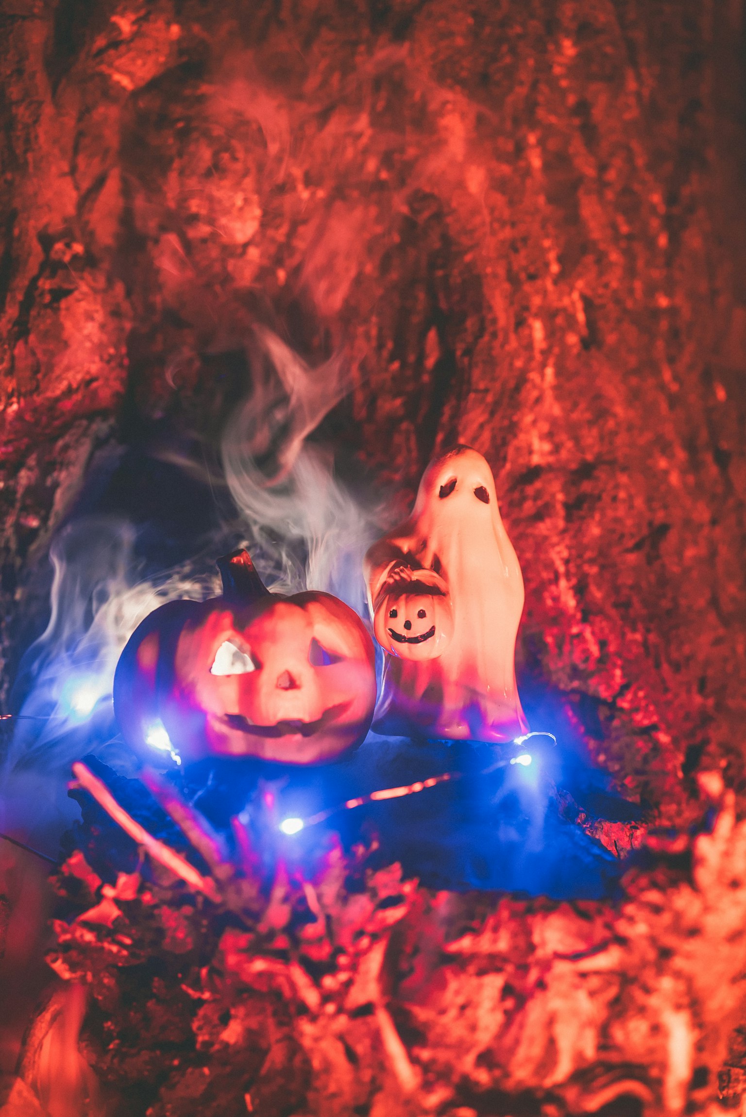ハロウィンのかぼちゃと小さな幽霊が青い光の中に並んでいる
