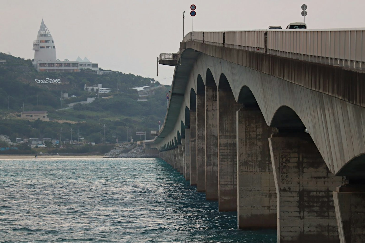 Photo d'un pont avec des arches et une vue sur la mer