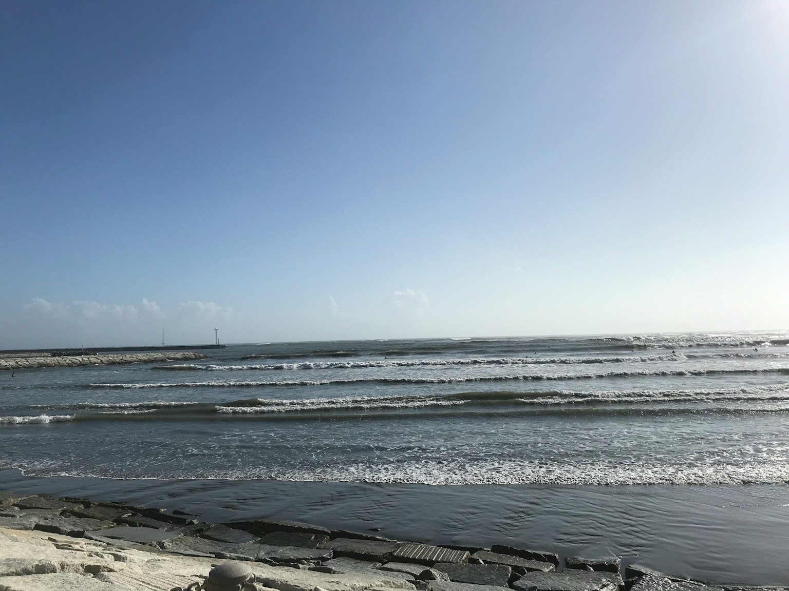 Pemandangan pantai dengan langit biru dan ombak lembut