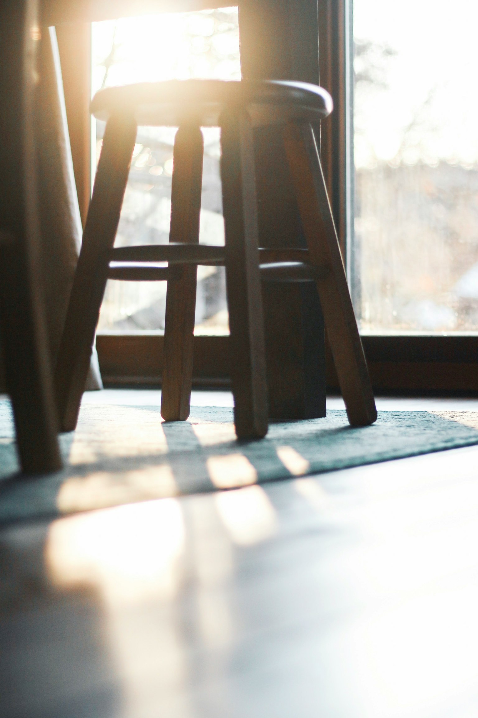 Tabouret en bois avec lumière du soleil passant par la fenêtre