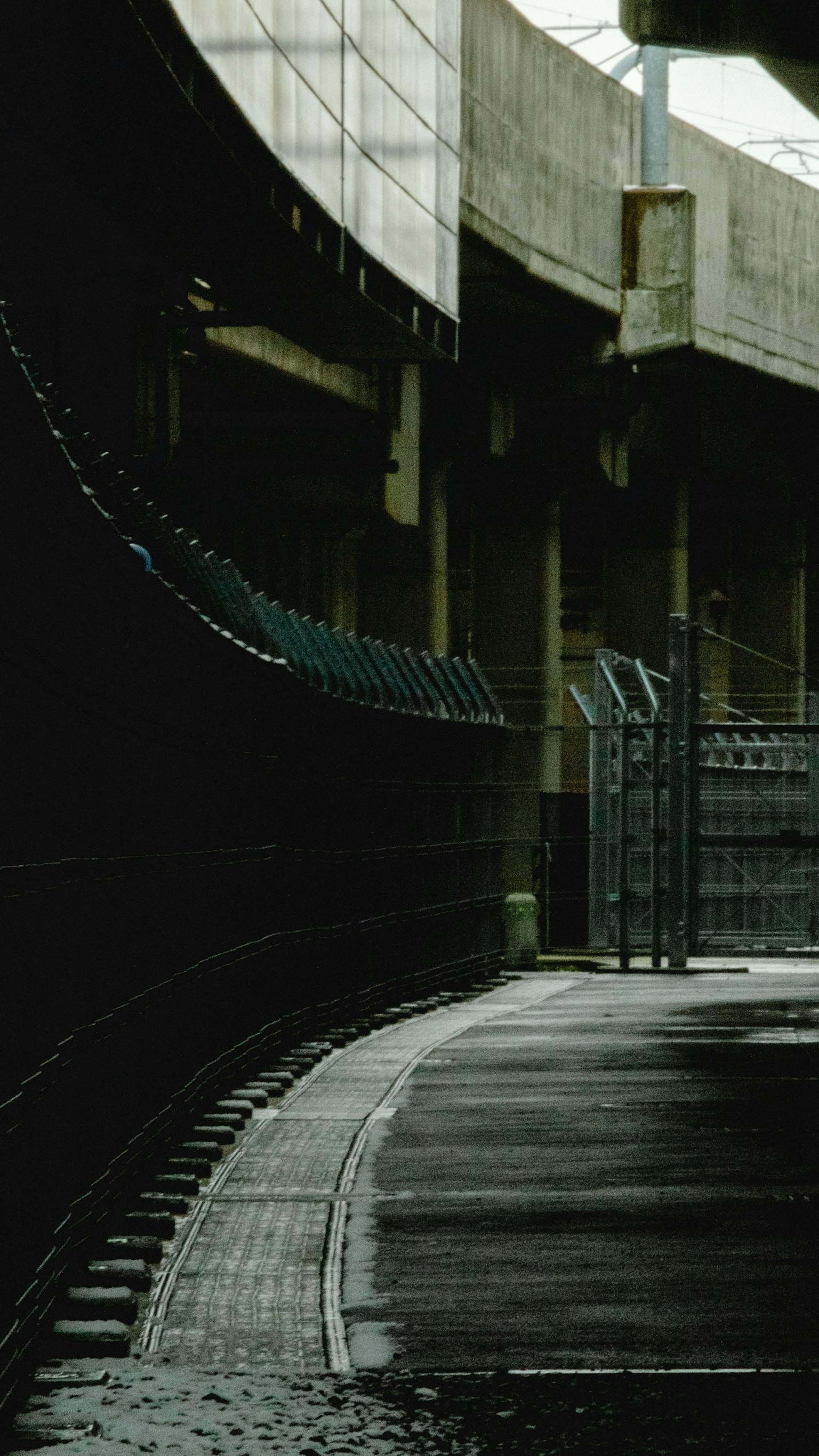 彎曲的小路旁是一個黑暗的結構和圍欄