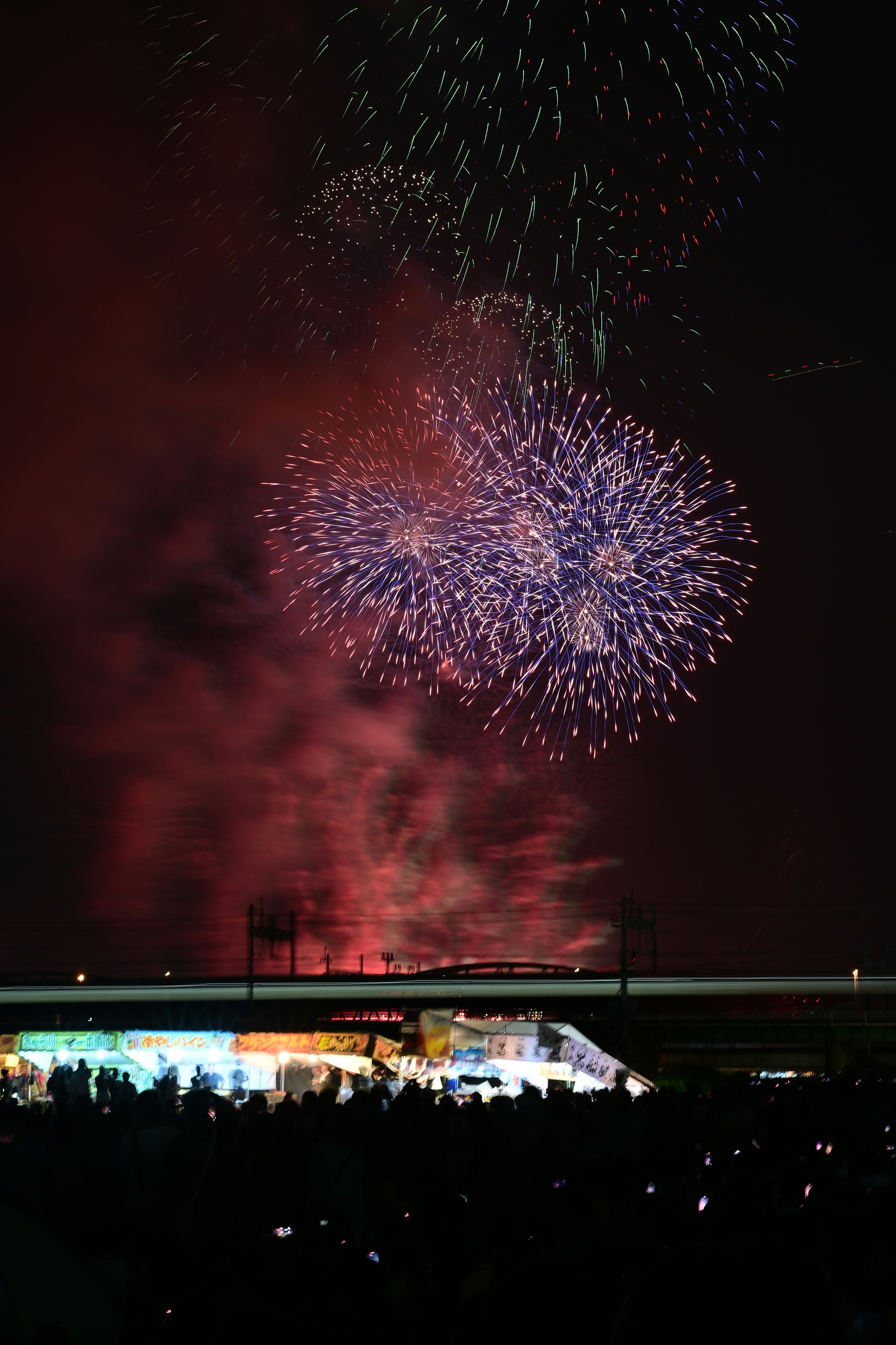 夜空に咲く花火と観客のいるスタジアムの眺め