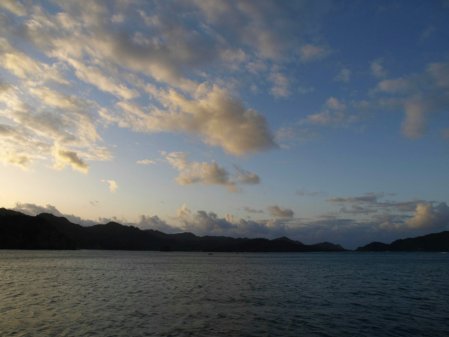 Serene sunset landscape with calm sea and clouds