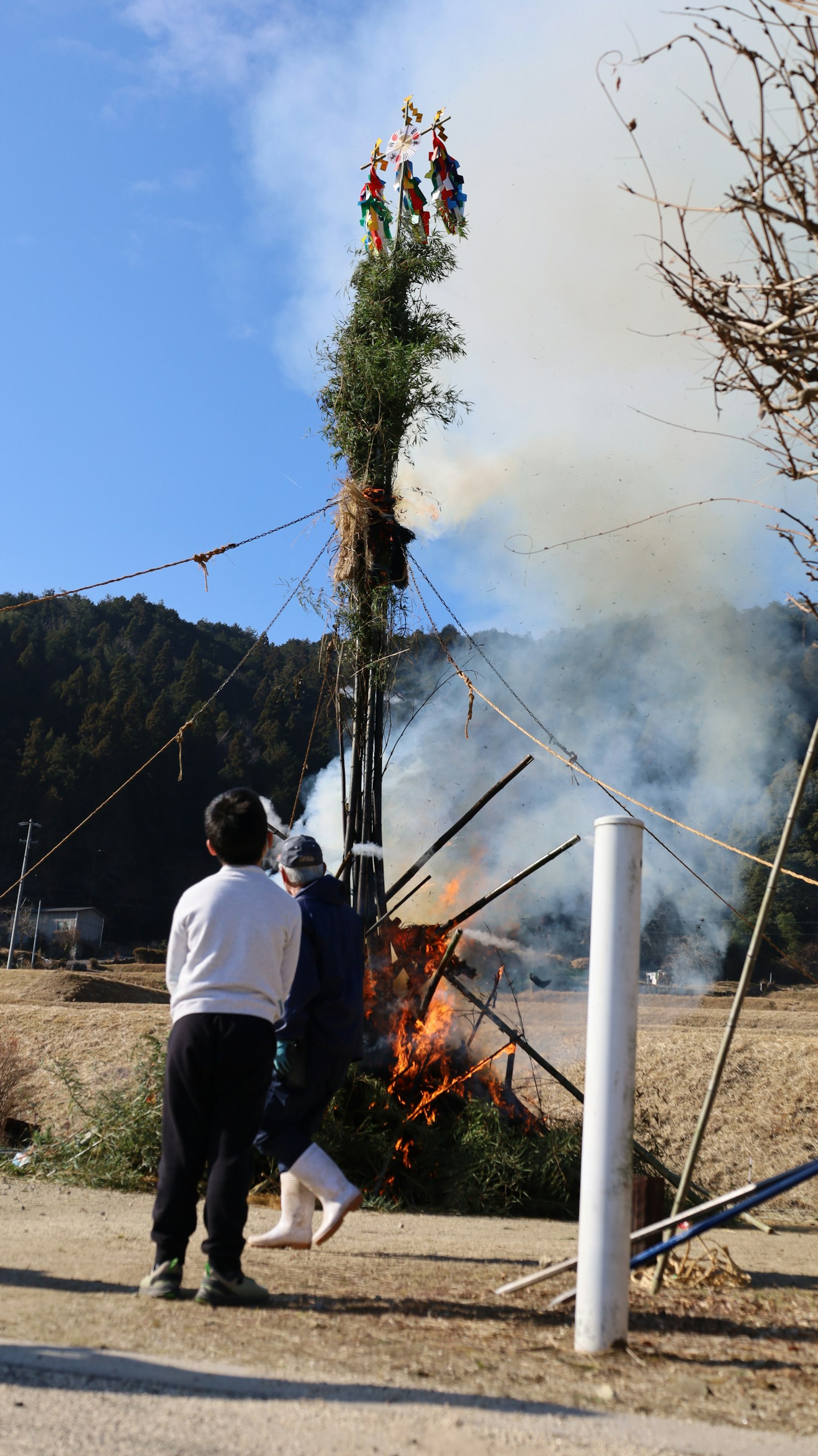 Personas reunidas alrededor de una hoguera durante un festival de fuego con humo ascendente