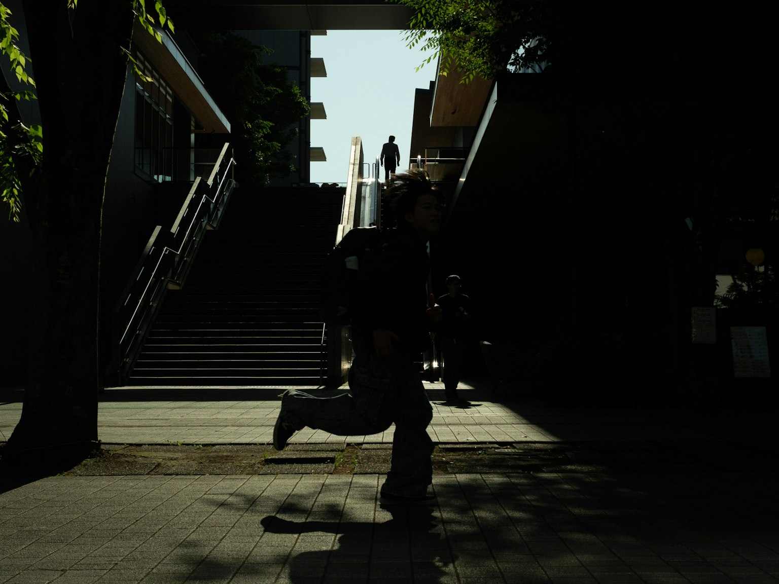Silhouette di una persona che corre giù per le scale con uno sfondo luminoso