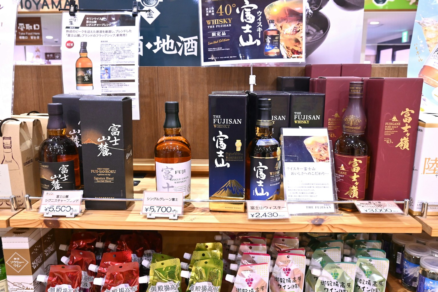 Display of whiskey bottles and packaging on a wooden shelf