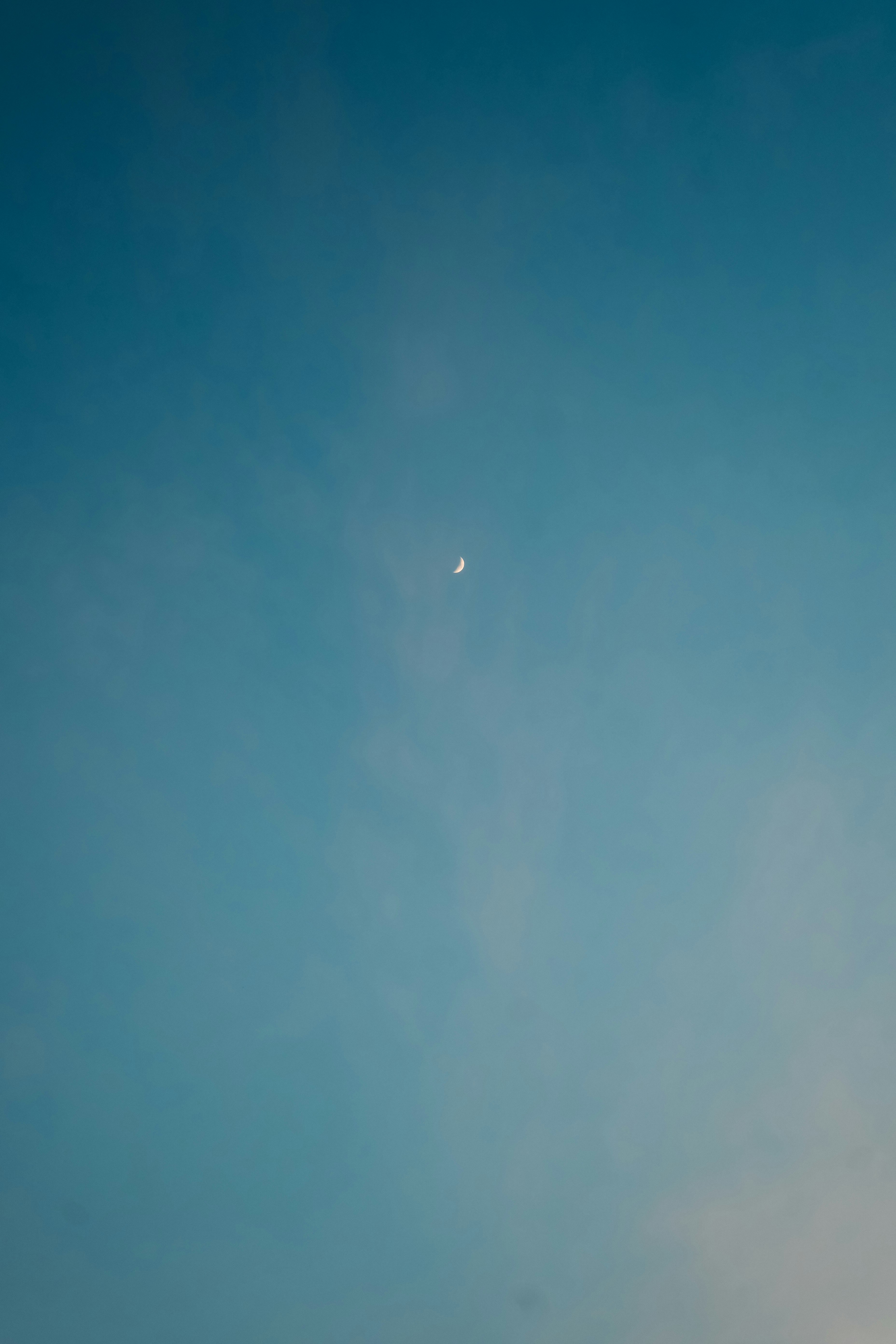 青空に浮かぶ月と薄い雲の気配