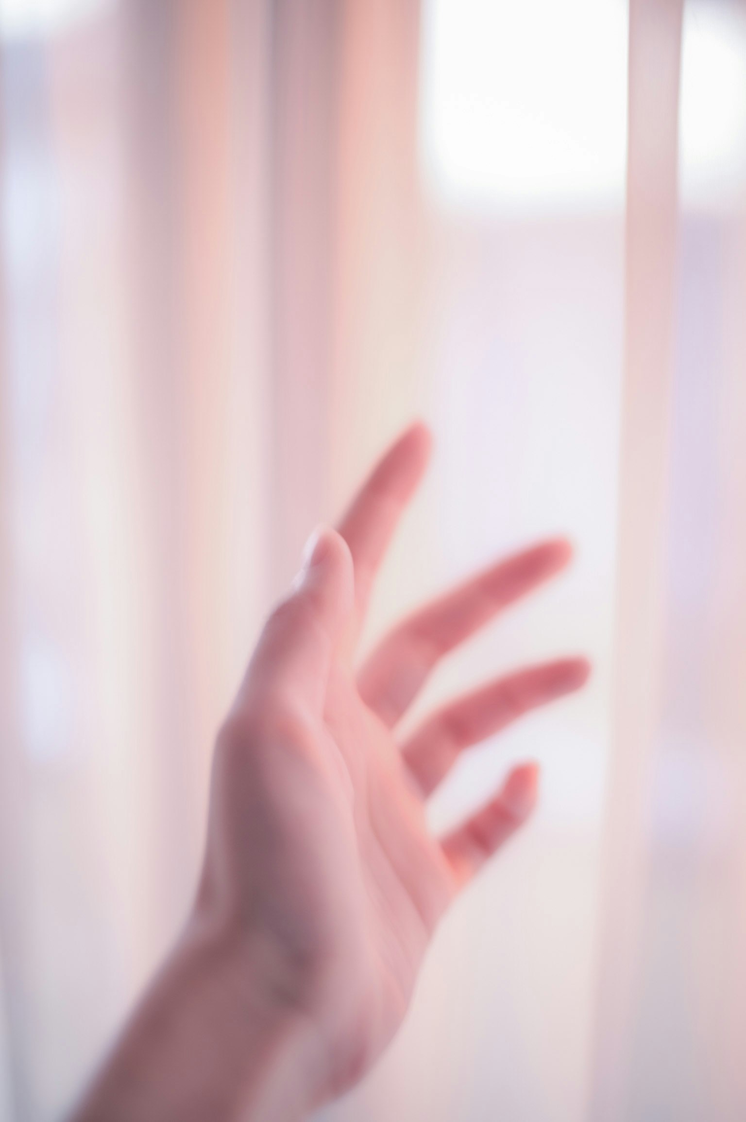 Eine Hand, die nach weichen Vorhängen greift