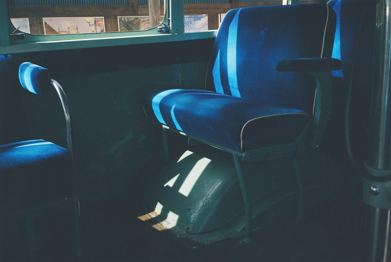 Interno di un autobus con sedili blu e ombre