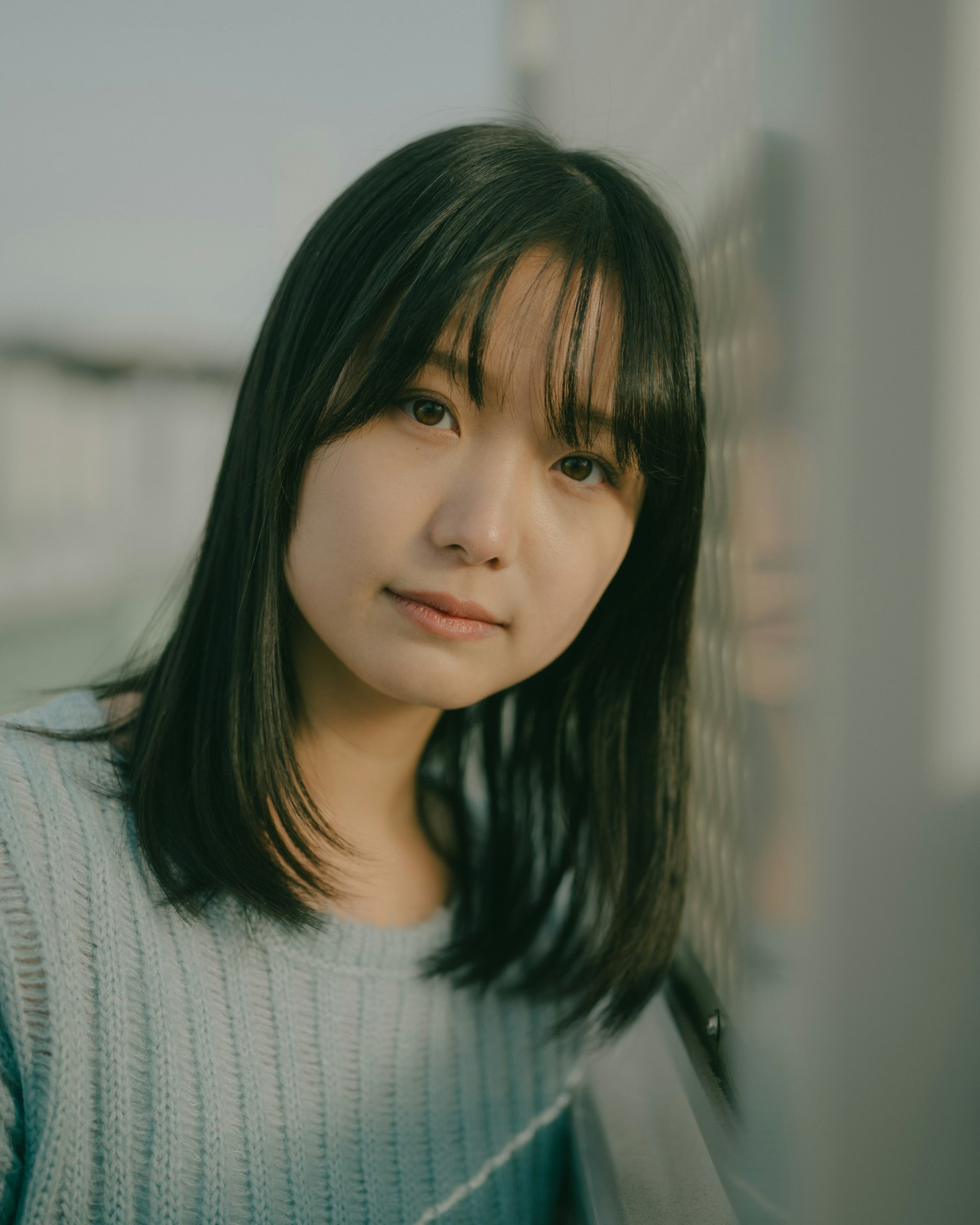 Một người phụ nữ trẻ nhìn nhẹ nhàng vào máy ảnh