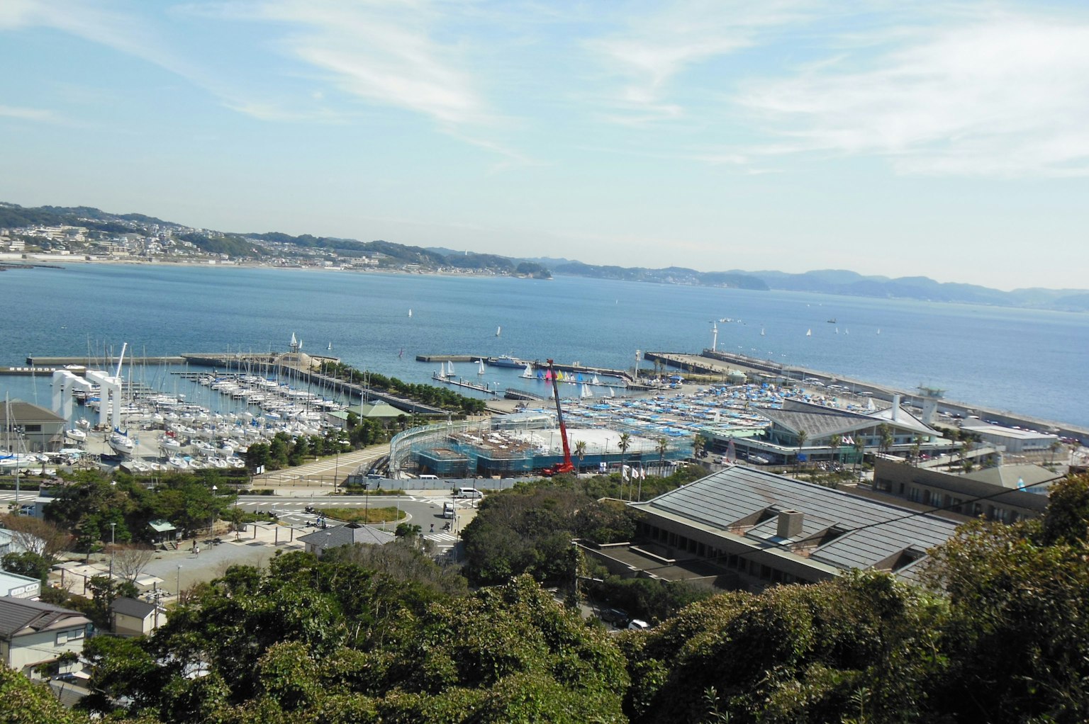 Panoramic view of the sea and marina showing cranes and buildings