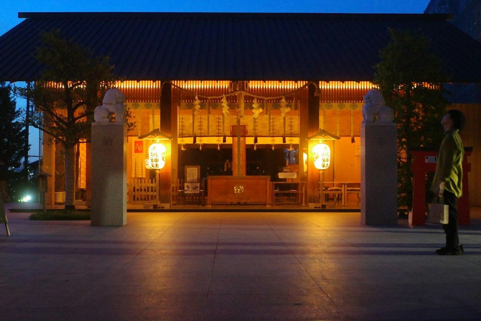 夜間照亮的傳統建築外觀和人影