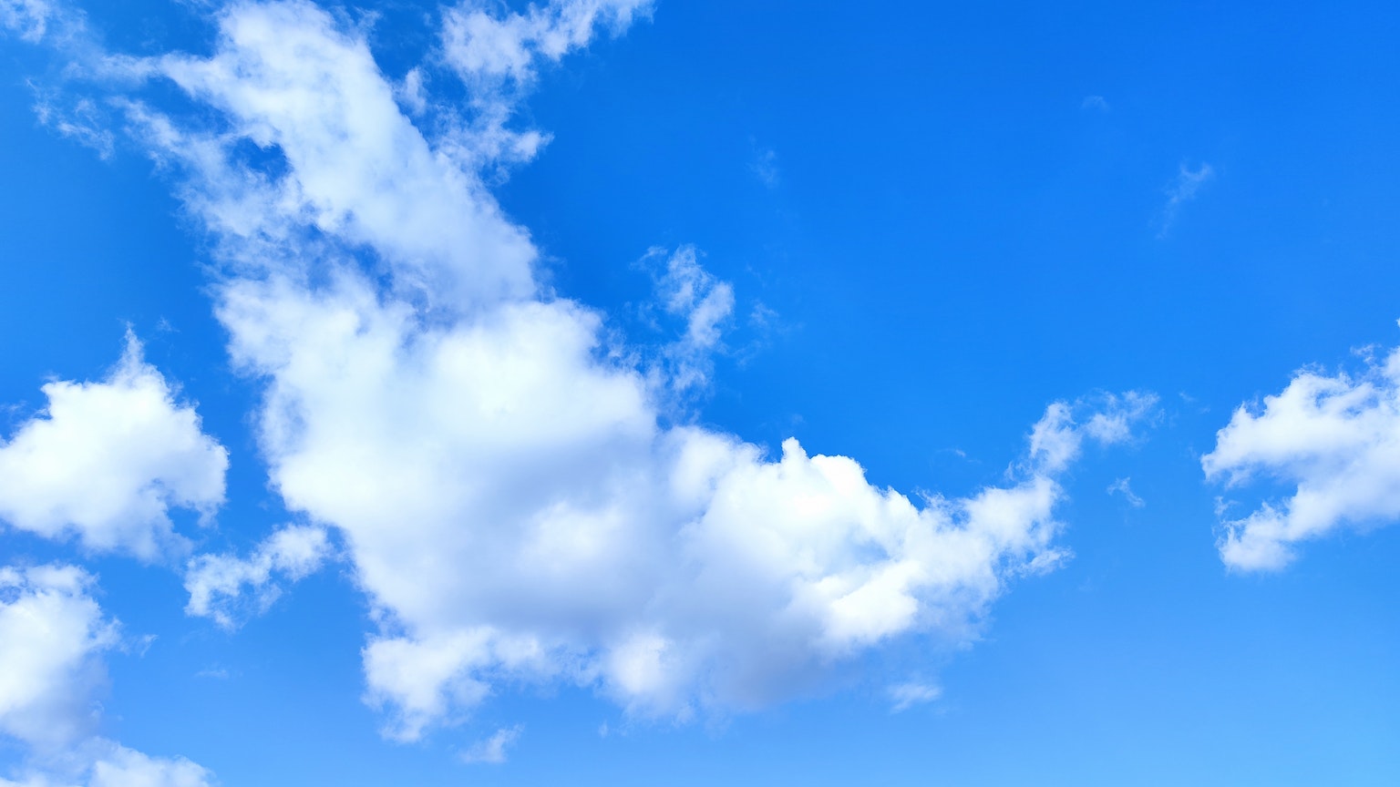 Ein klarer blauer Himmel mit fluffigen weißen Wolken