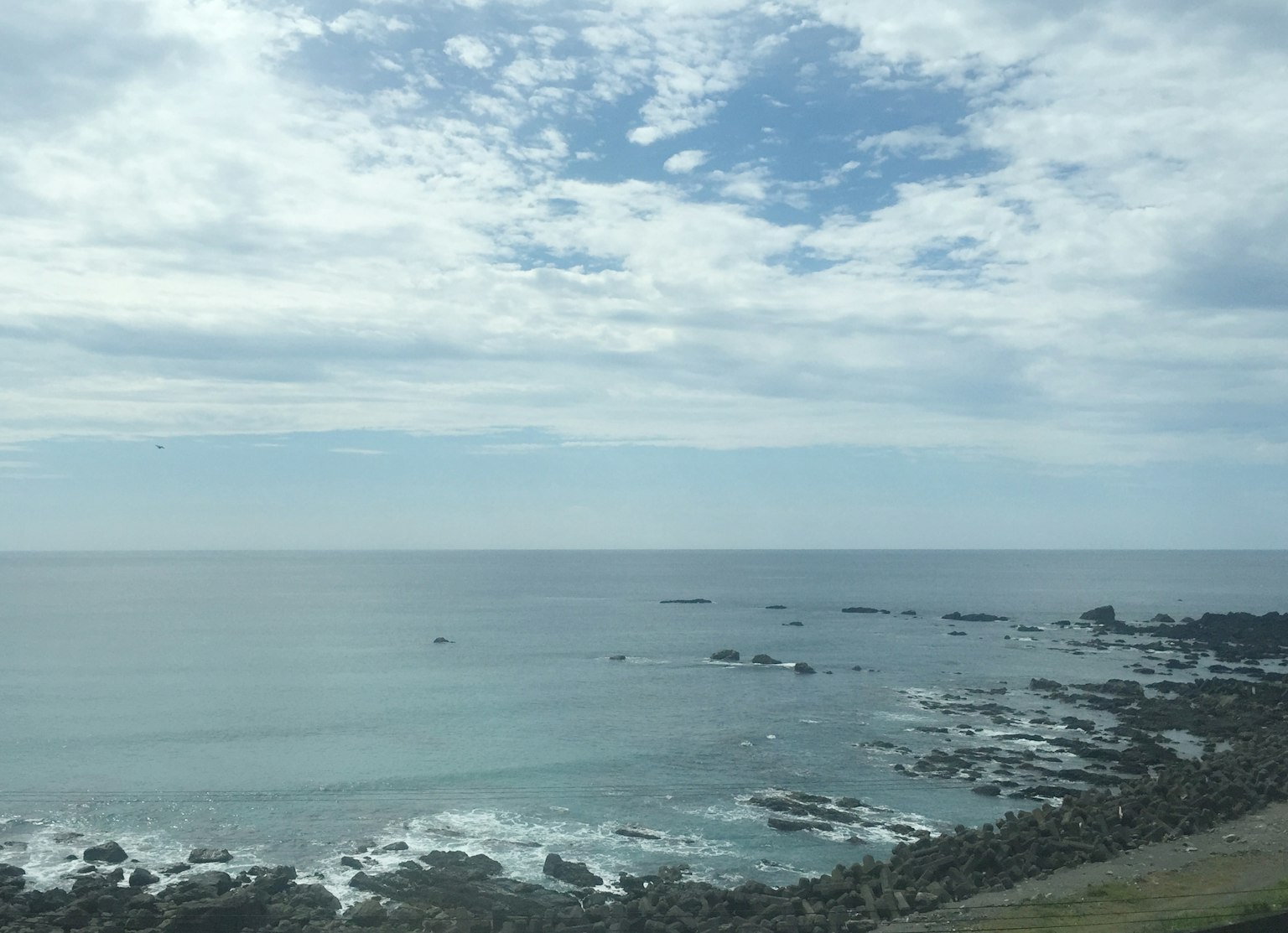 ทิวทัศน์ชายฝั่งที่มีทะเลสีฟ้าและชายหาดหิน