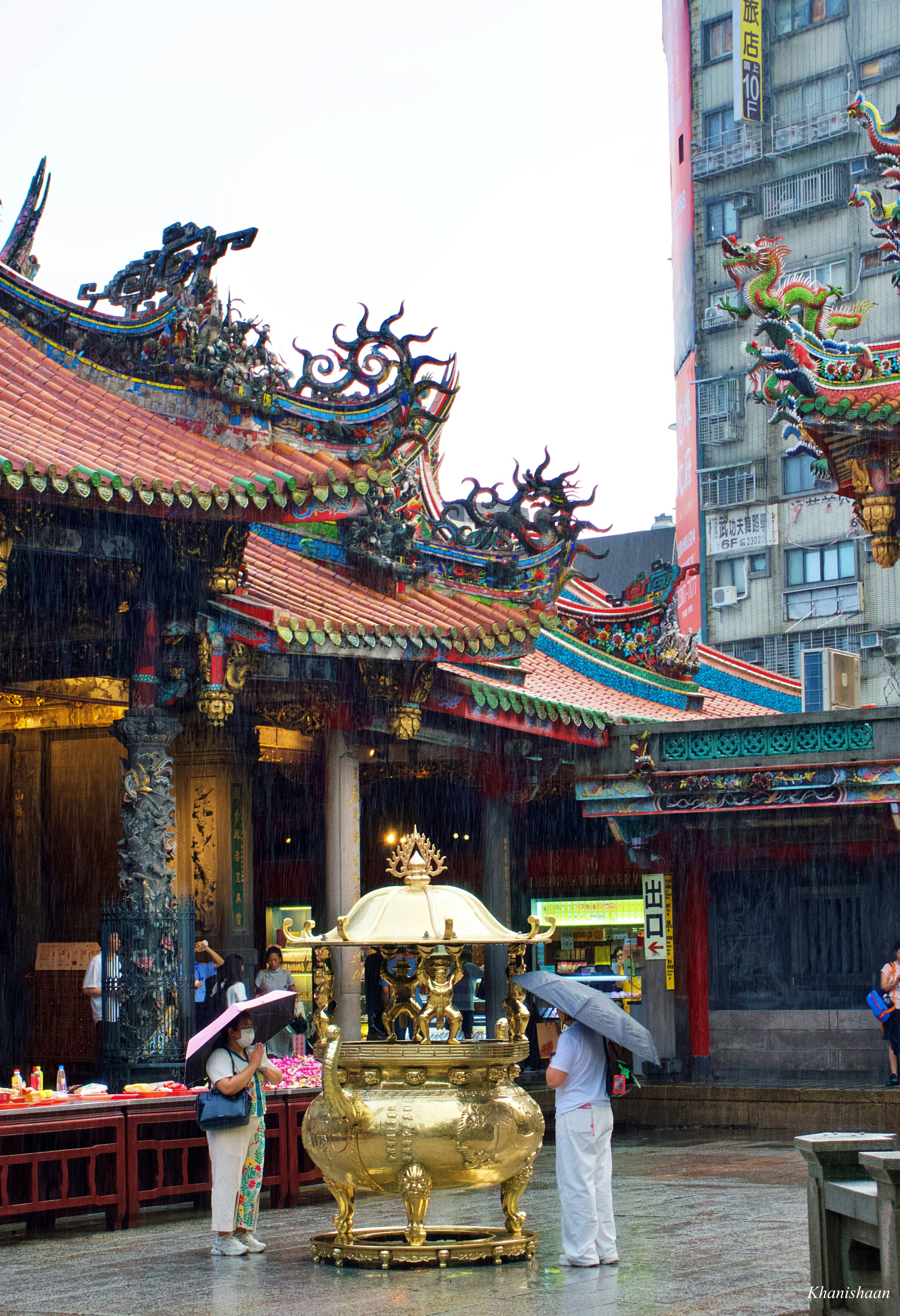寺院の門前で香炉を囲む人々のある参拝風景