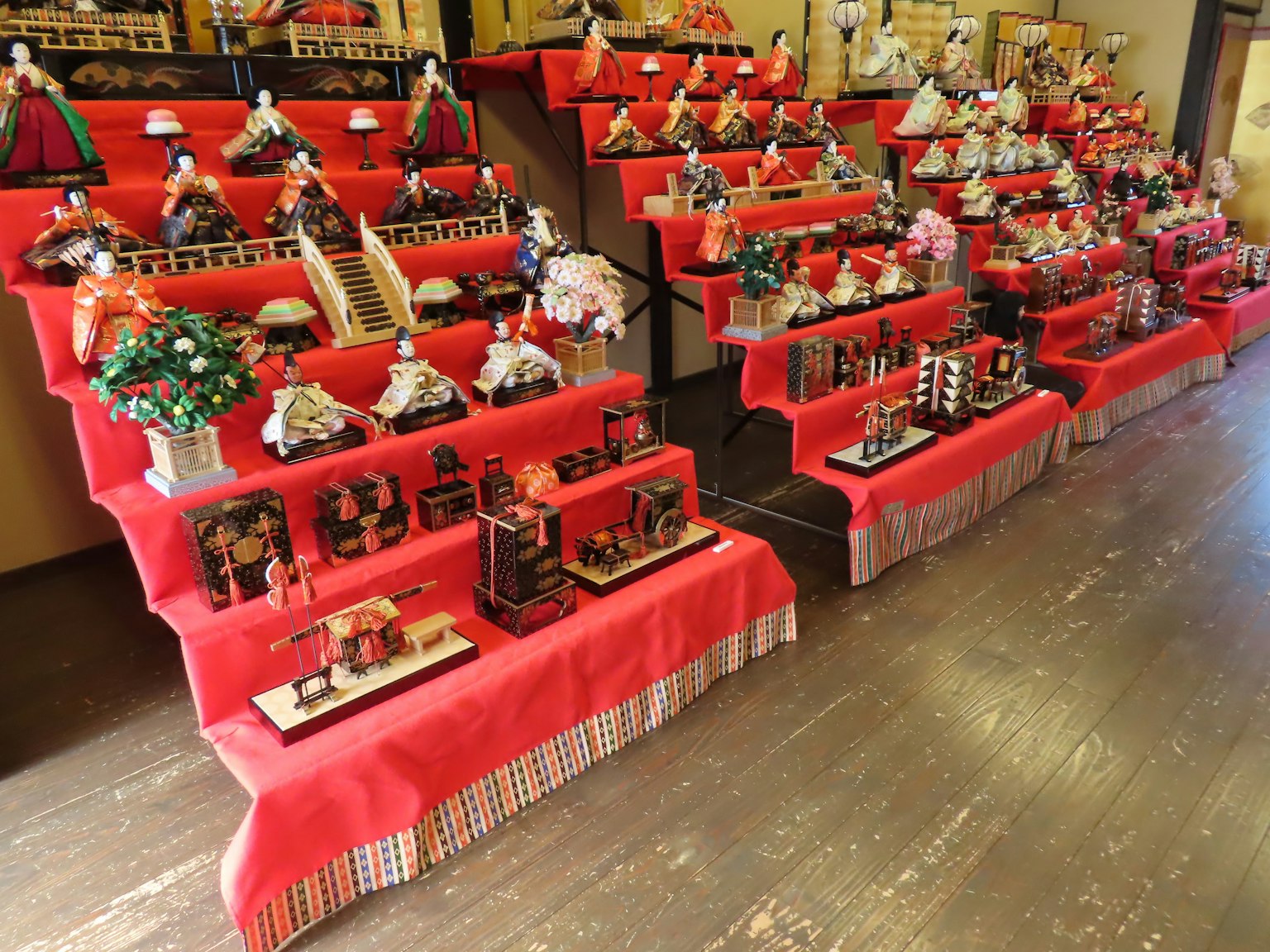 Traditional hina dolls and decorations displayed on red tablecloths