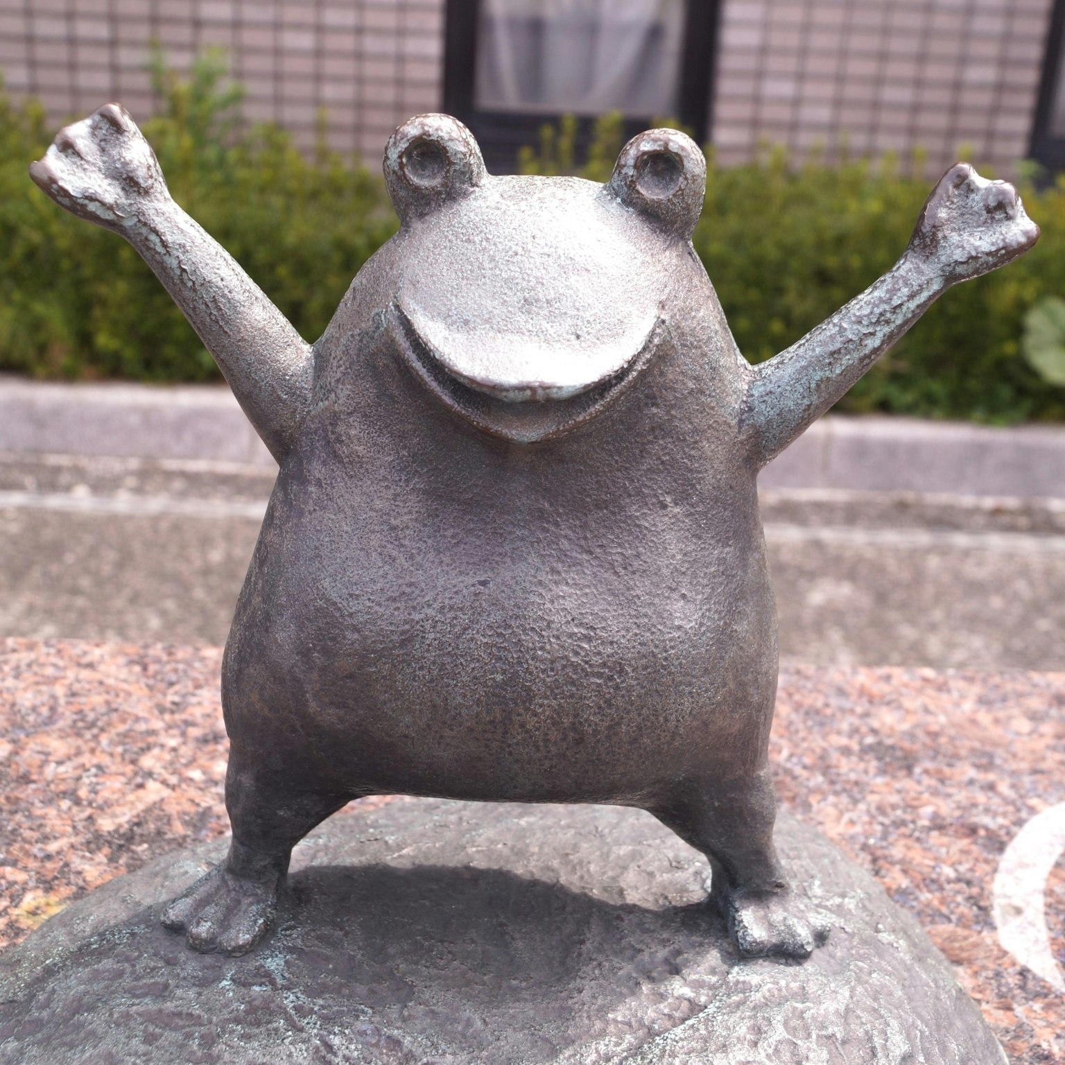 Patung katak perunggu ceria dengan tangan terangkat