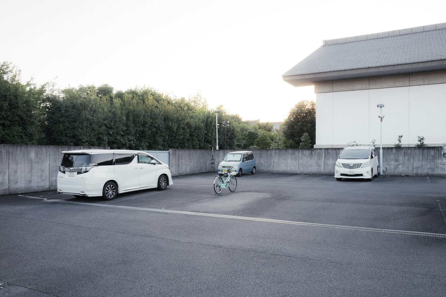 Un parcheggio con diverse auto parcheggiate e una bicicletta
