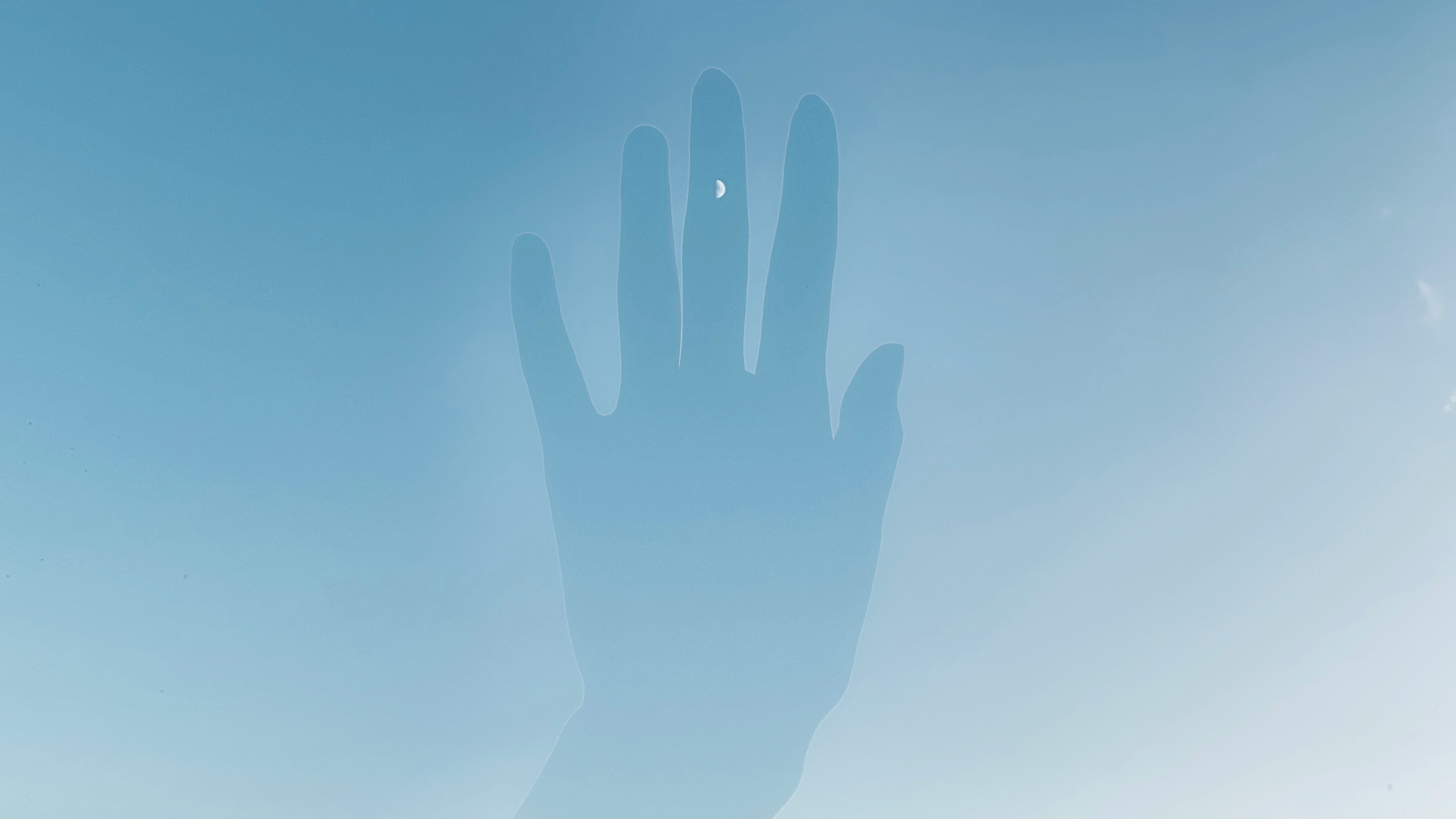 青空の下に浮かぶ手のシルエット