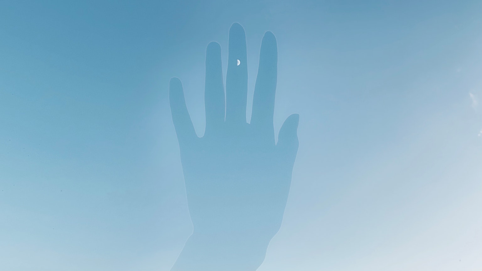 Silueta de una mano sobre un fondo azul