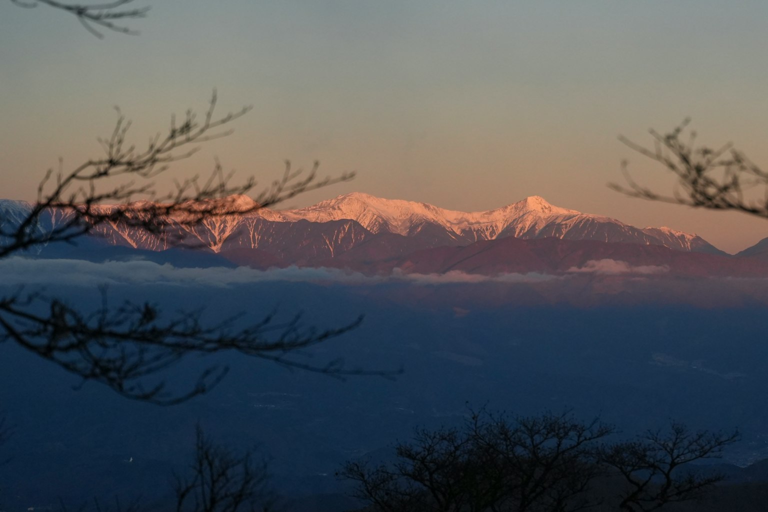 Paisaje montañoso al atardecer con picos nevados