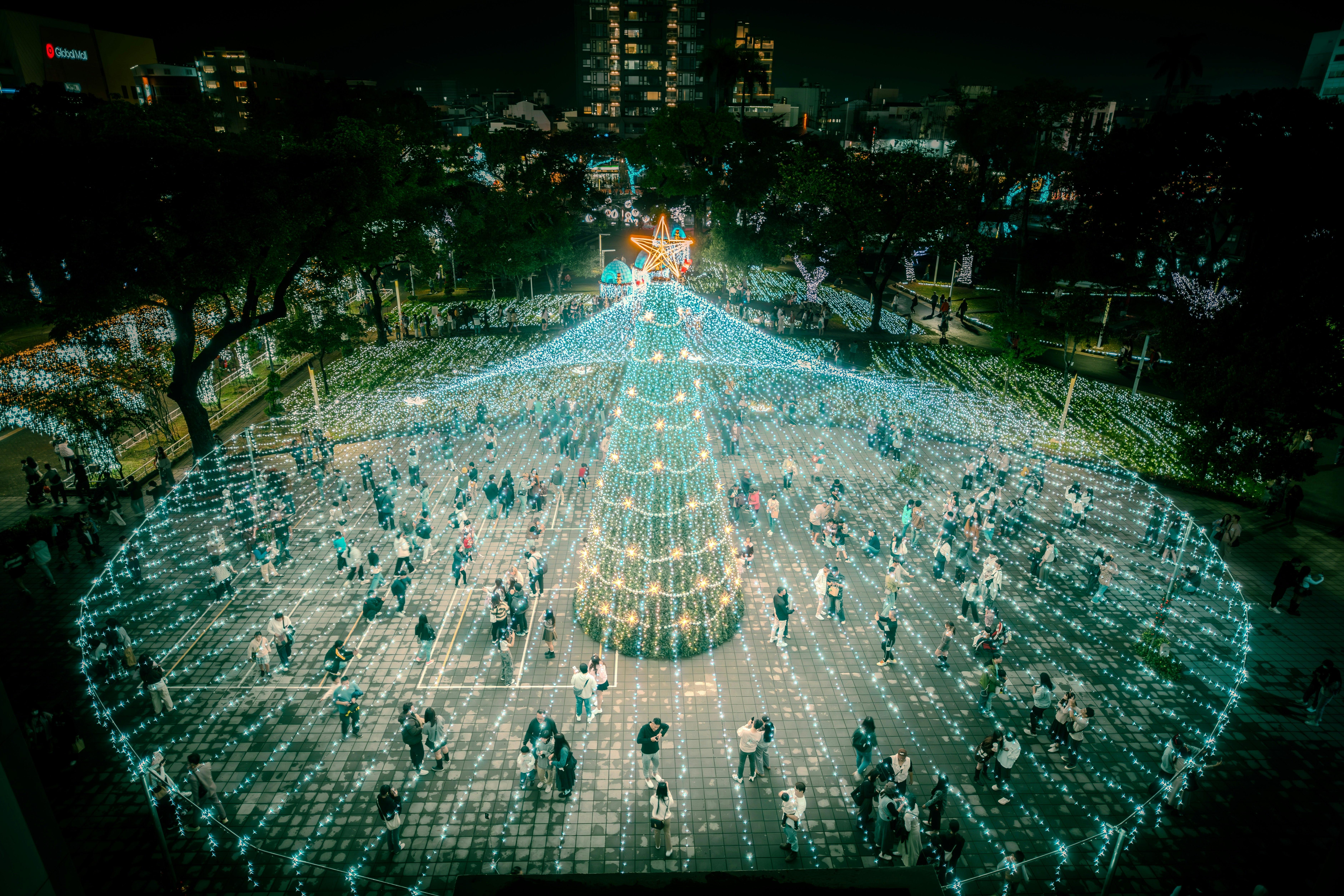 iluminación nocturna sobre una gran plaza llena de luces