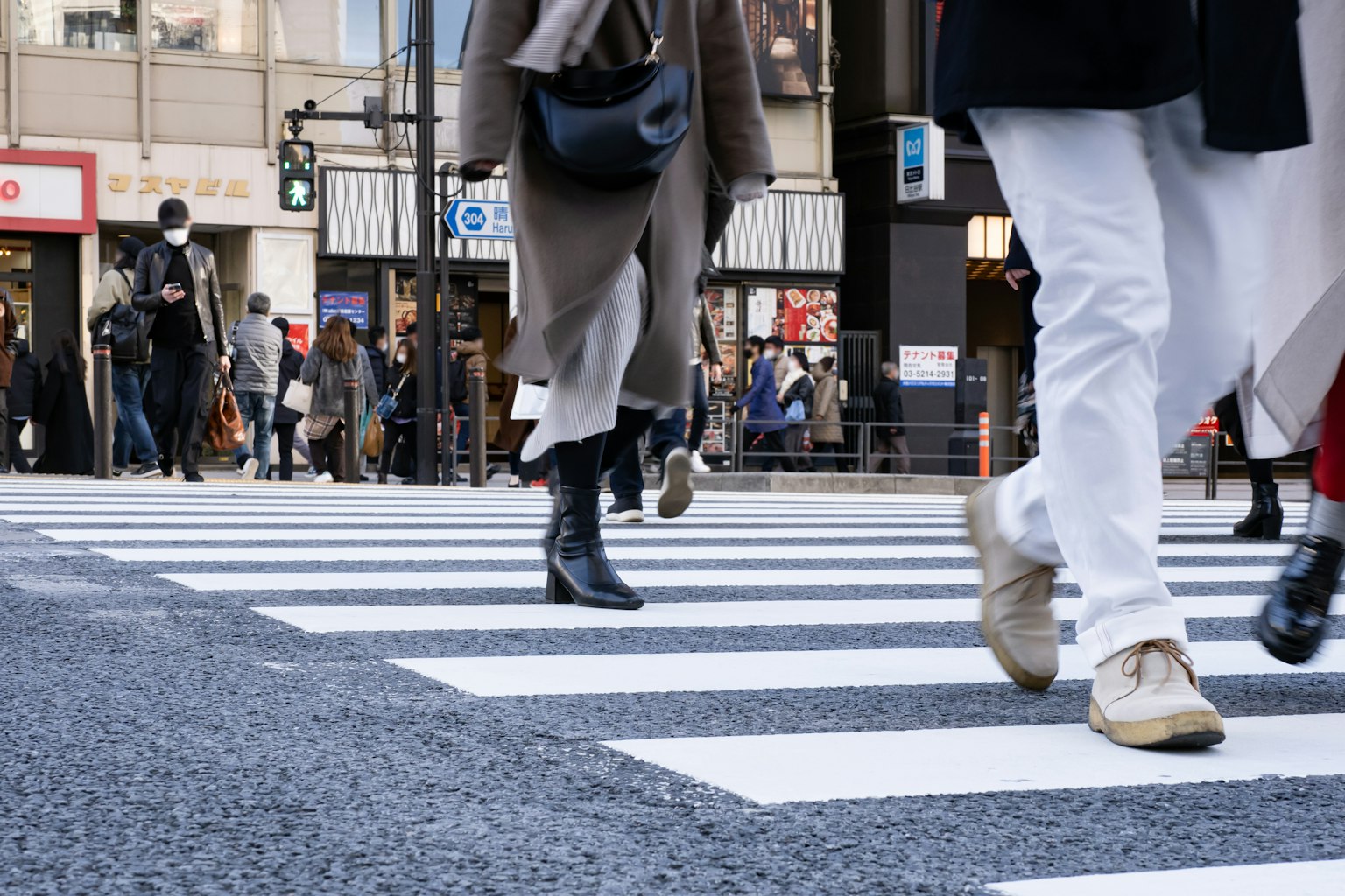Fußabdrücke von Fußgängern, die eine Straße in einer belebten Stadt überqueren