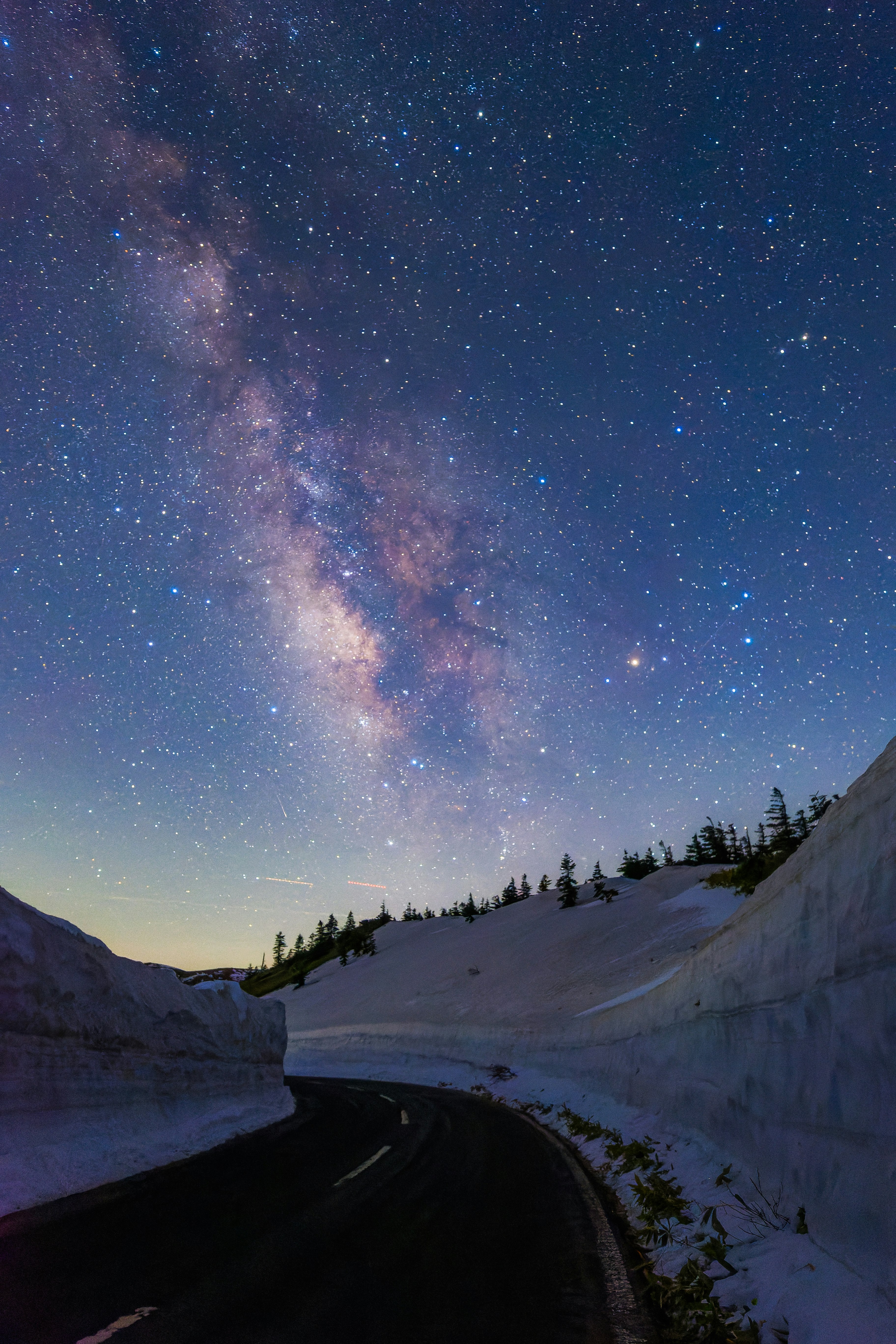 天の川が見える夜の山道と雪の斜面