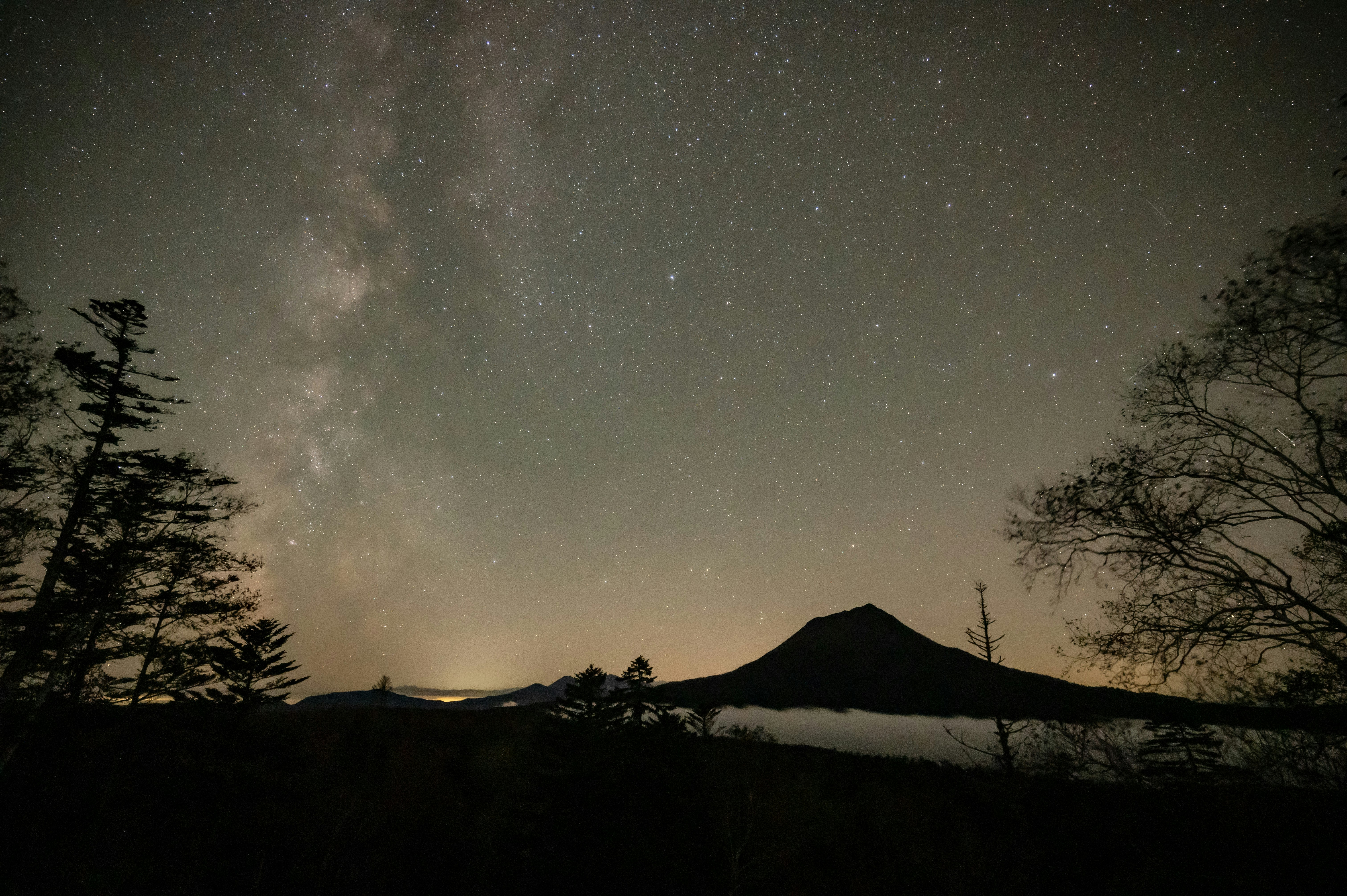 Voie lactée au-dessus d’une silhouette de montagne la nuit