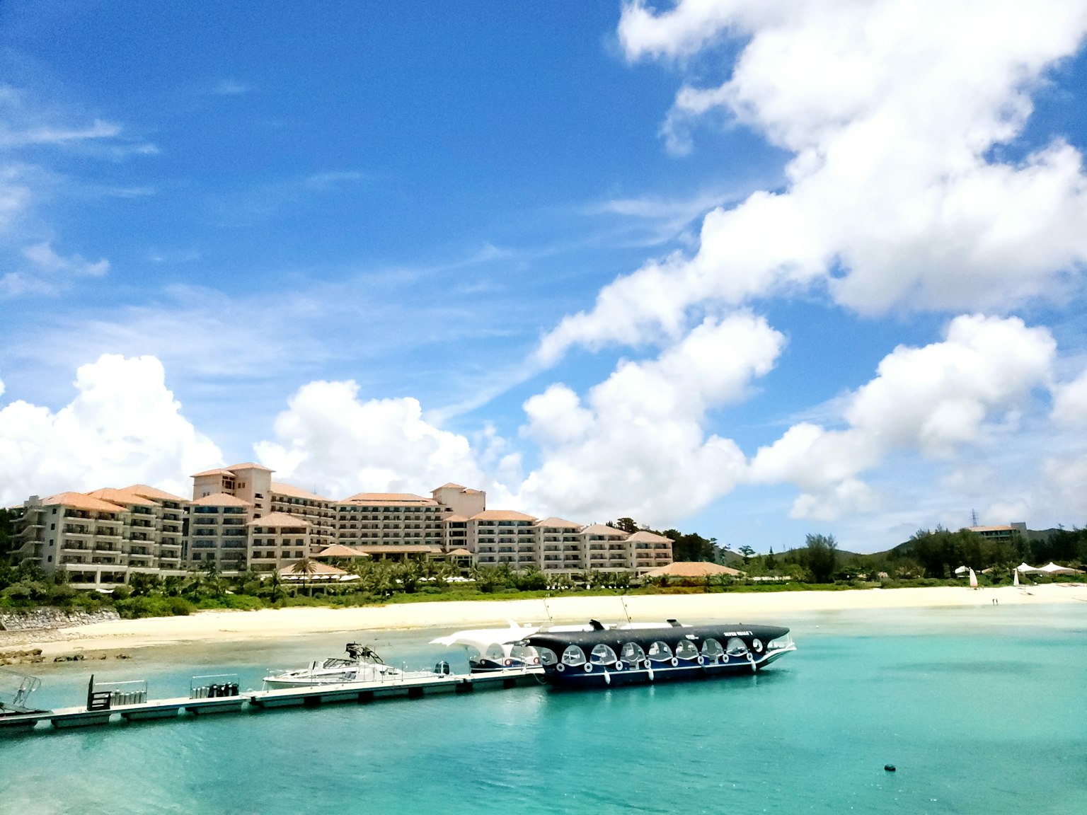 ทิวทัศน์ของรีสอร์ทที่มีมหาสมุทรสีน้ำเงินและชายหาดทรายขาว