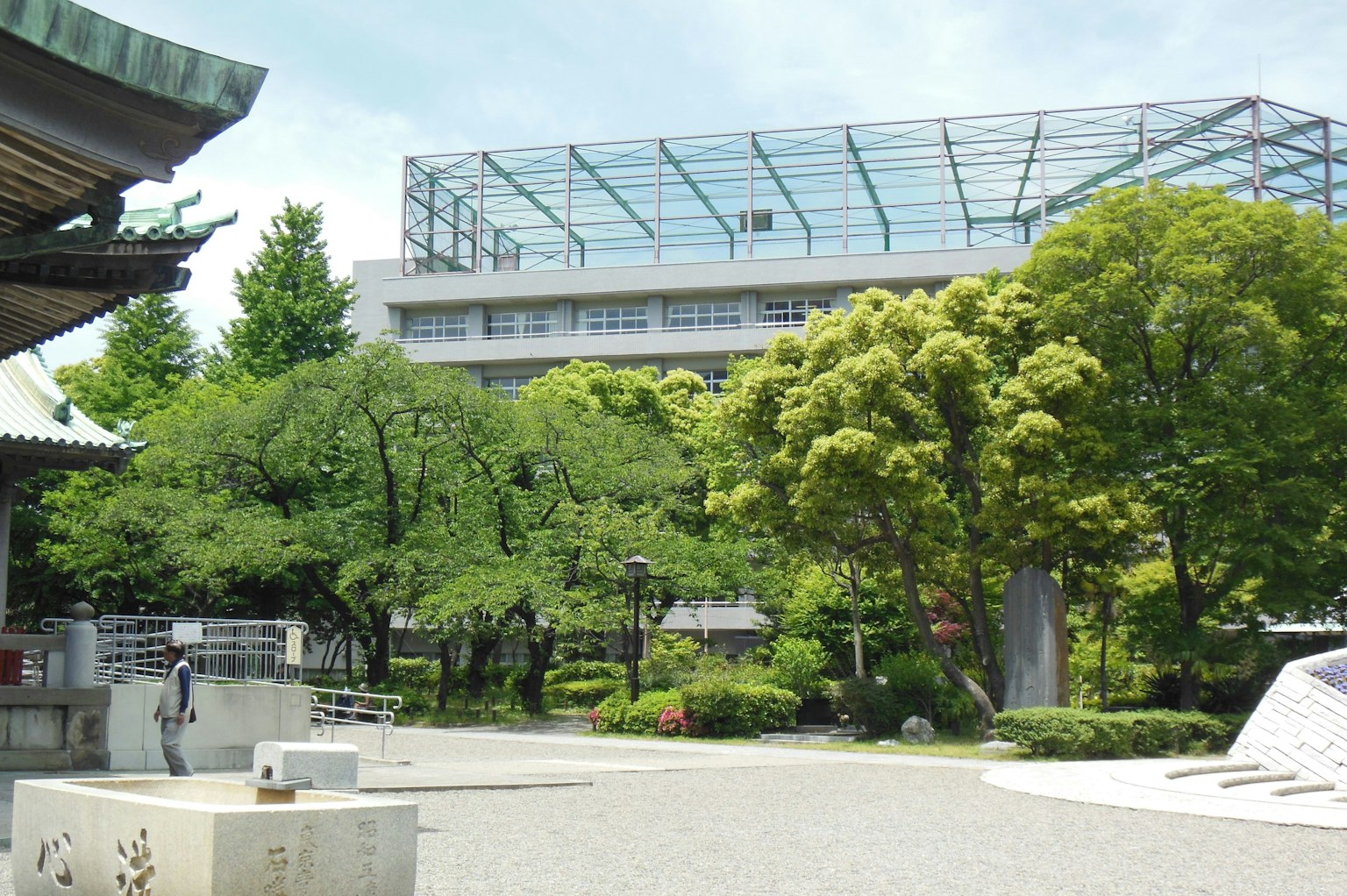 一個現代建築被郁郁蔥蔥的綠色和傳統建築包圍的風景