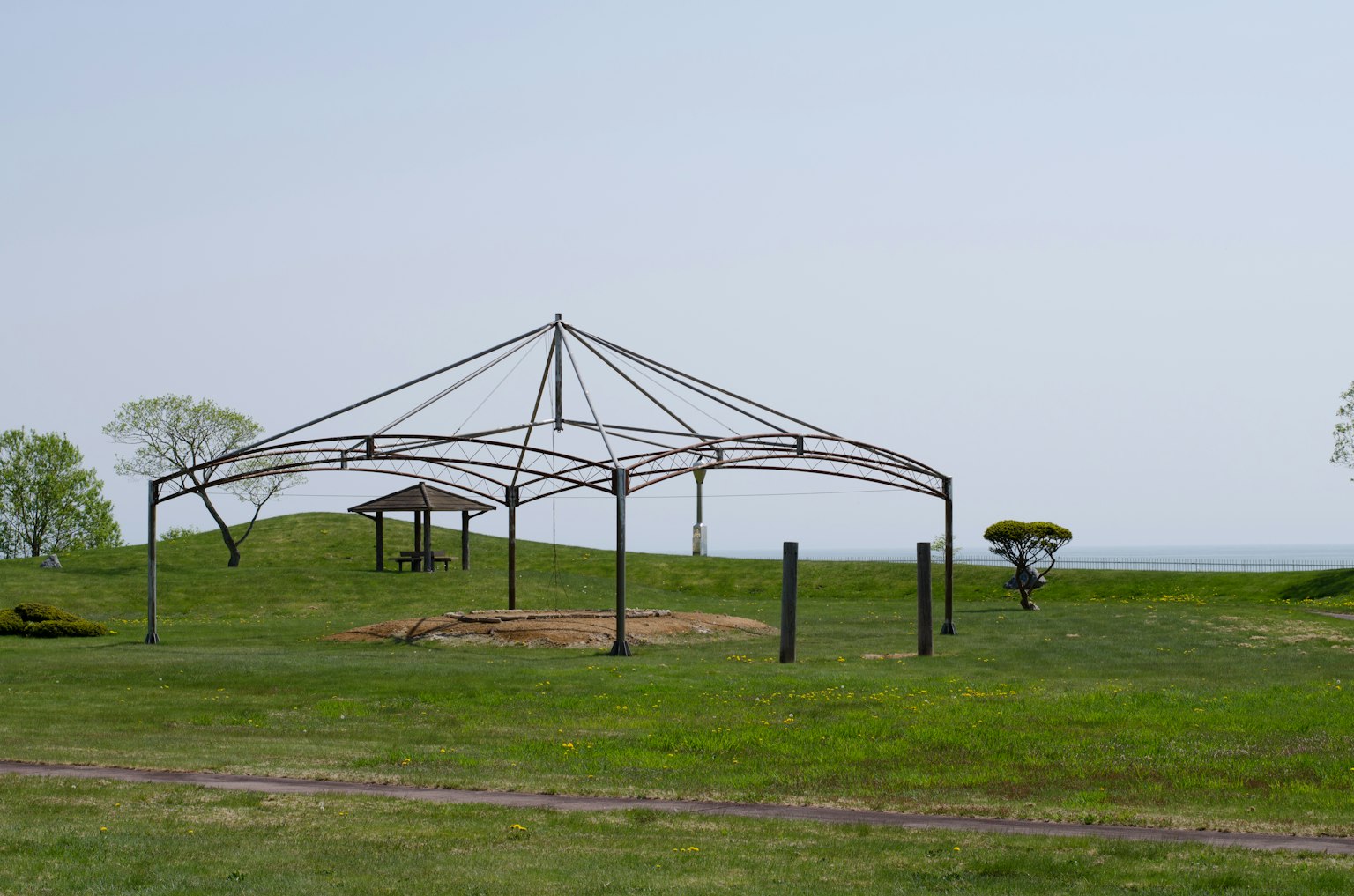 Una struttura di tenda in metallo montata su un campo erboso sotto un cielo aperto