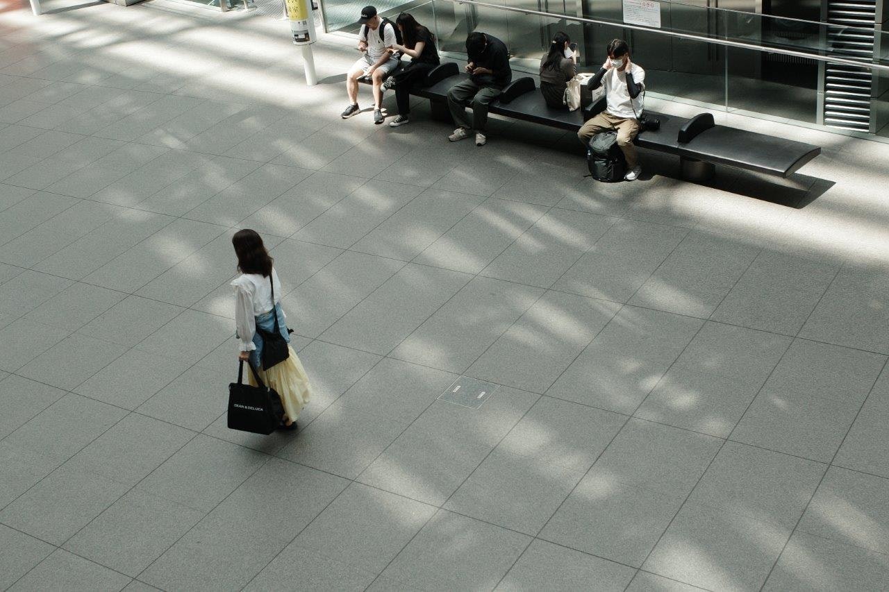 people waiting on benches in a spacious station concourse