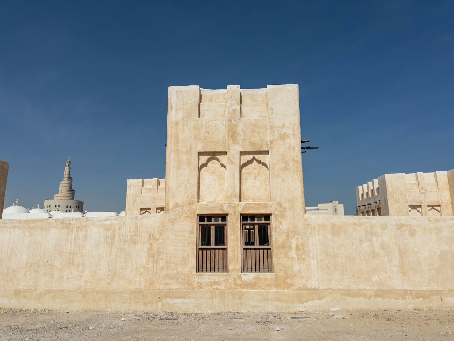 Arquitectura árabe tradicional con pared texturizada y ventanas de madera