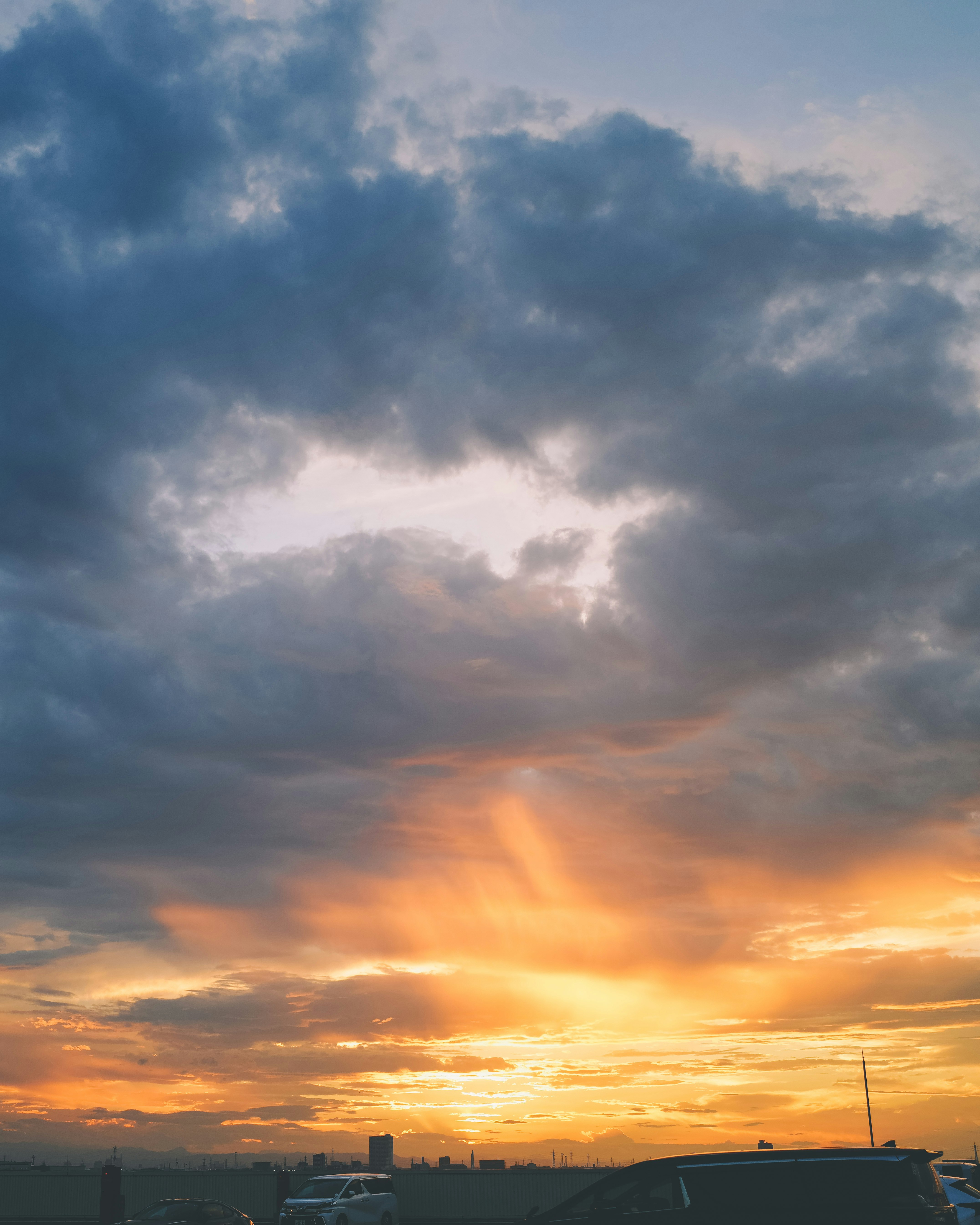 夕焼けの空に広がる雲と街並みのシルエット