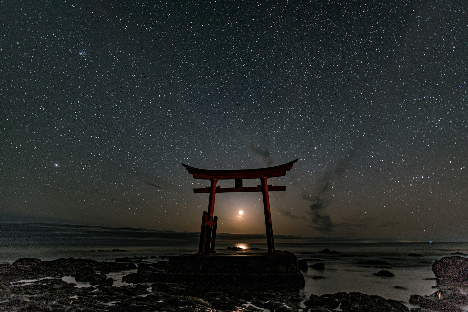 海边的红色鸟居在星空下