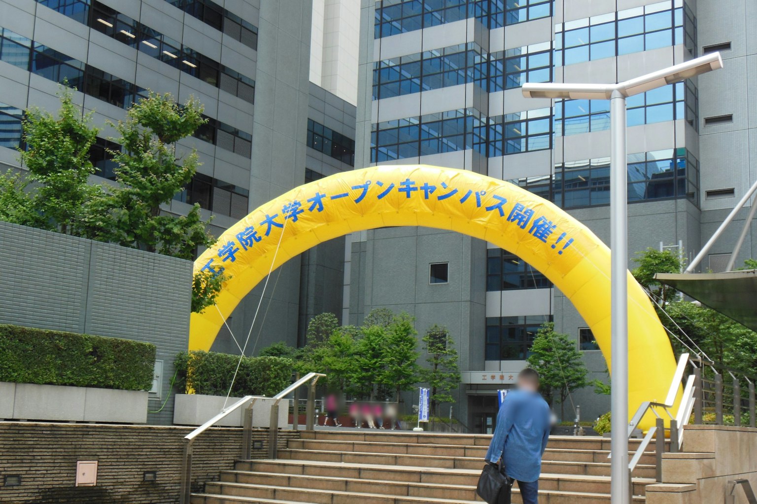 University campus entrance with a yellow arch and modern buildings